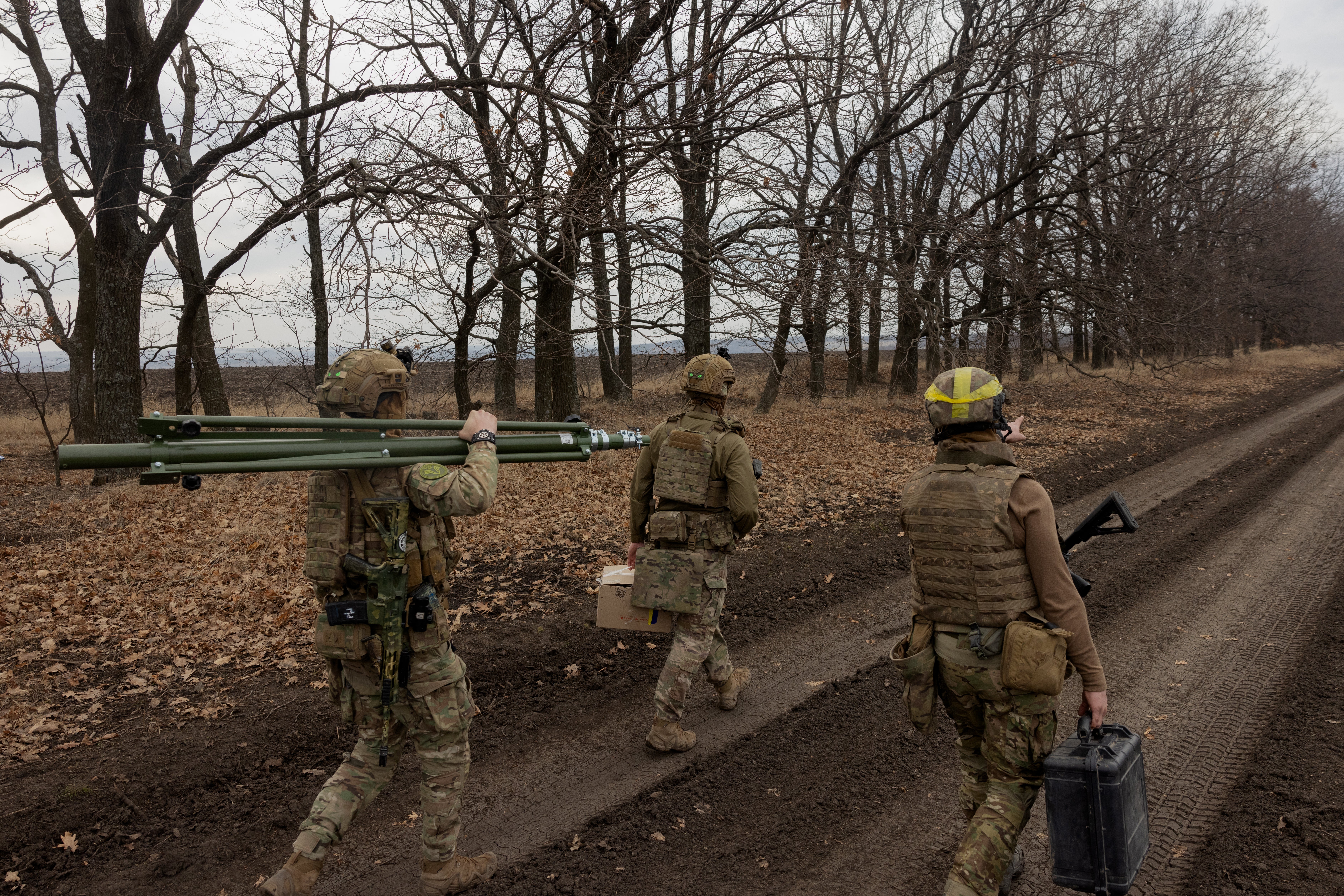 Ukrainian servicemen of the 3rd Operational Assignment Spartan Brigade carry equipment as they search for a location to launch a drone during a military training in Dnipropetrovsk Region on 10 March 2025
