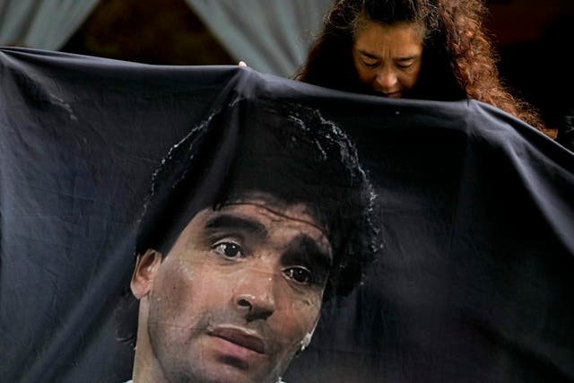 <p>A fan of late soccer star Diego Maradona holds his image outside the court where members of the medical team that treated Maradona go on trial for alleged homicide by negligence in San Isidro on the outskirts of Buenos Aires, Argentina, Tuesday, March 11, 2025</p>