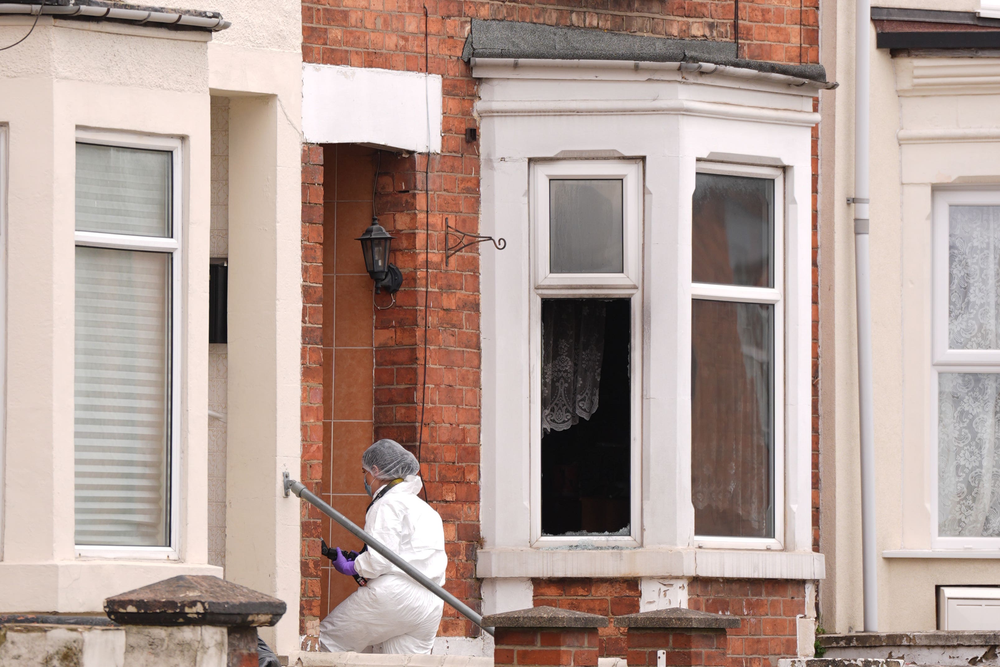 A forensics officer enters a house in Wellingborough’s Newcomen Road (Joe Giddens/PA)