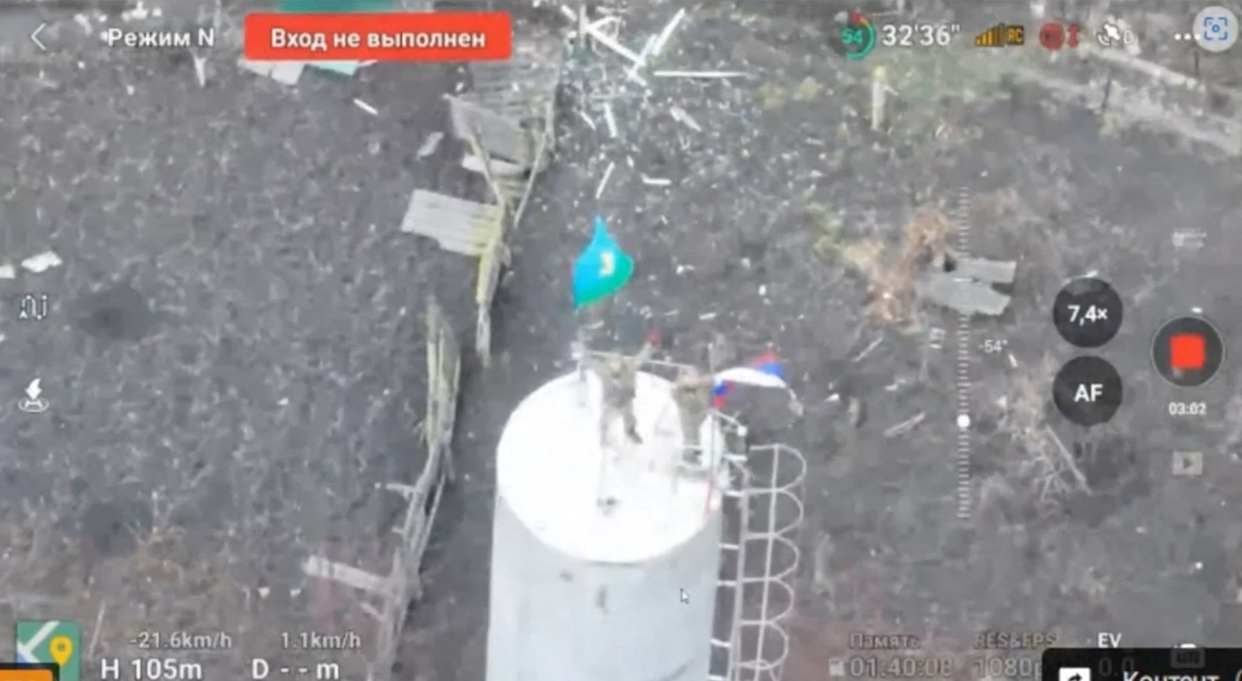 A drone view shows men dressed in military uniform waving flags, including the state flag of Russia, and standing on a water tower in the centre of Sudzha town in the course of Russia-Ukraine conflict