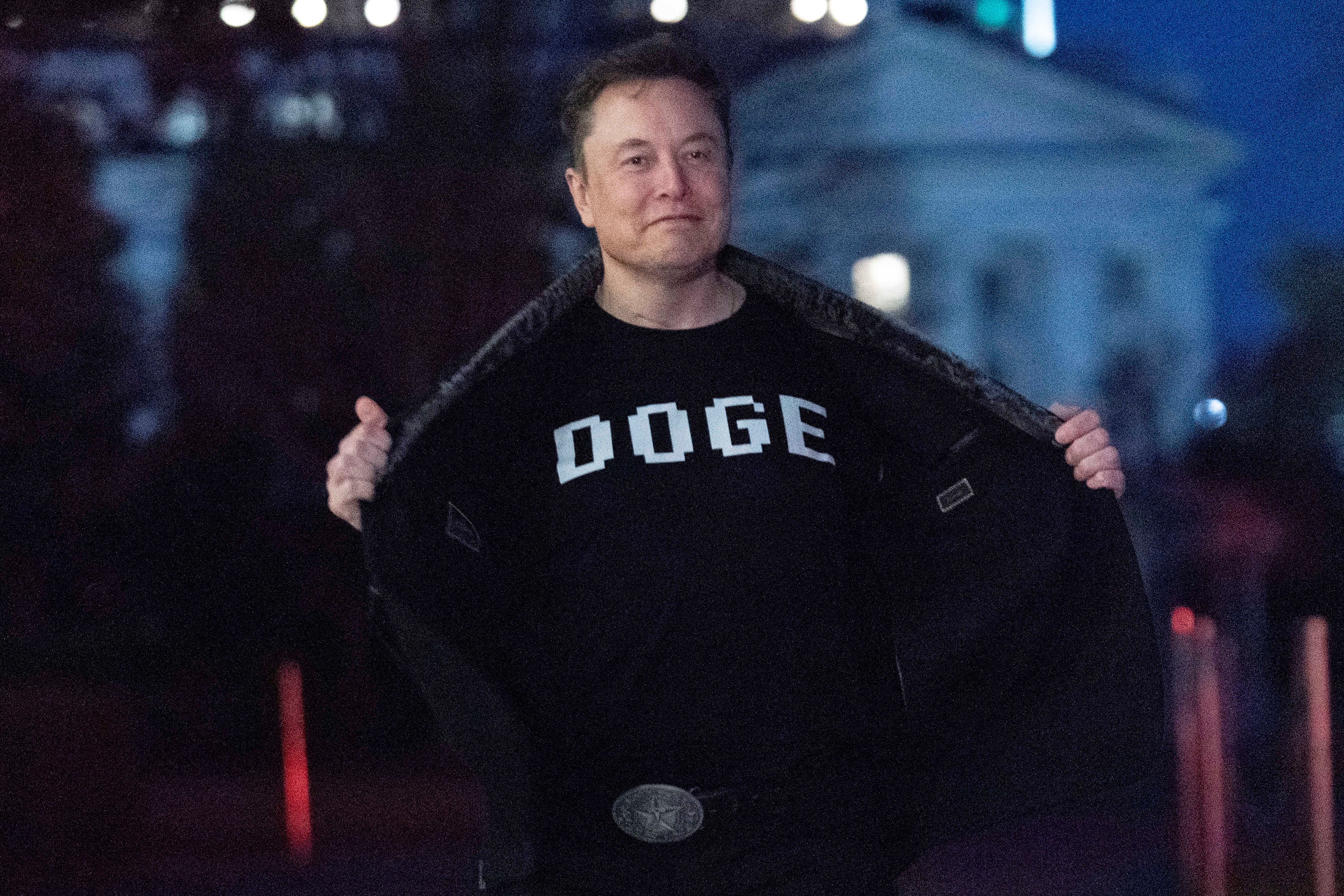 Elon Musk flashes his t-shirt that reads 