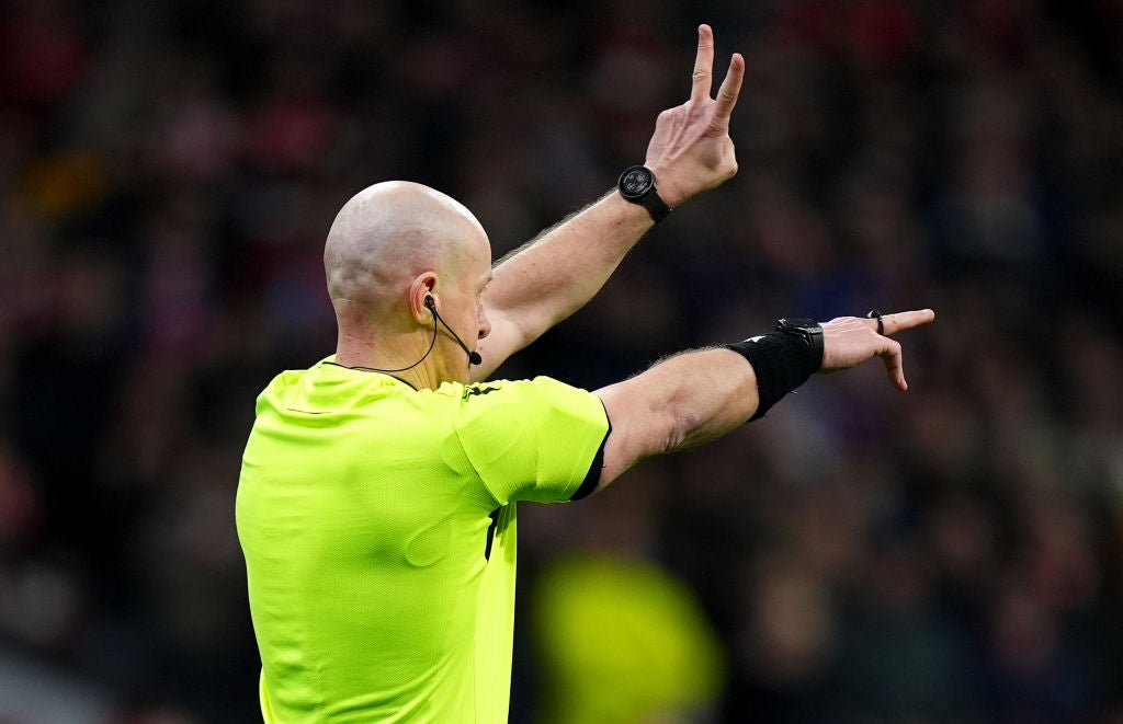 Referee Szymon Marciniak gestures as the penalty is ruled out following a VAR review