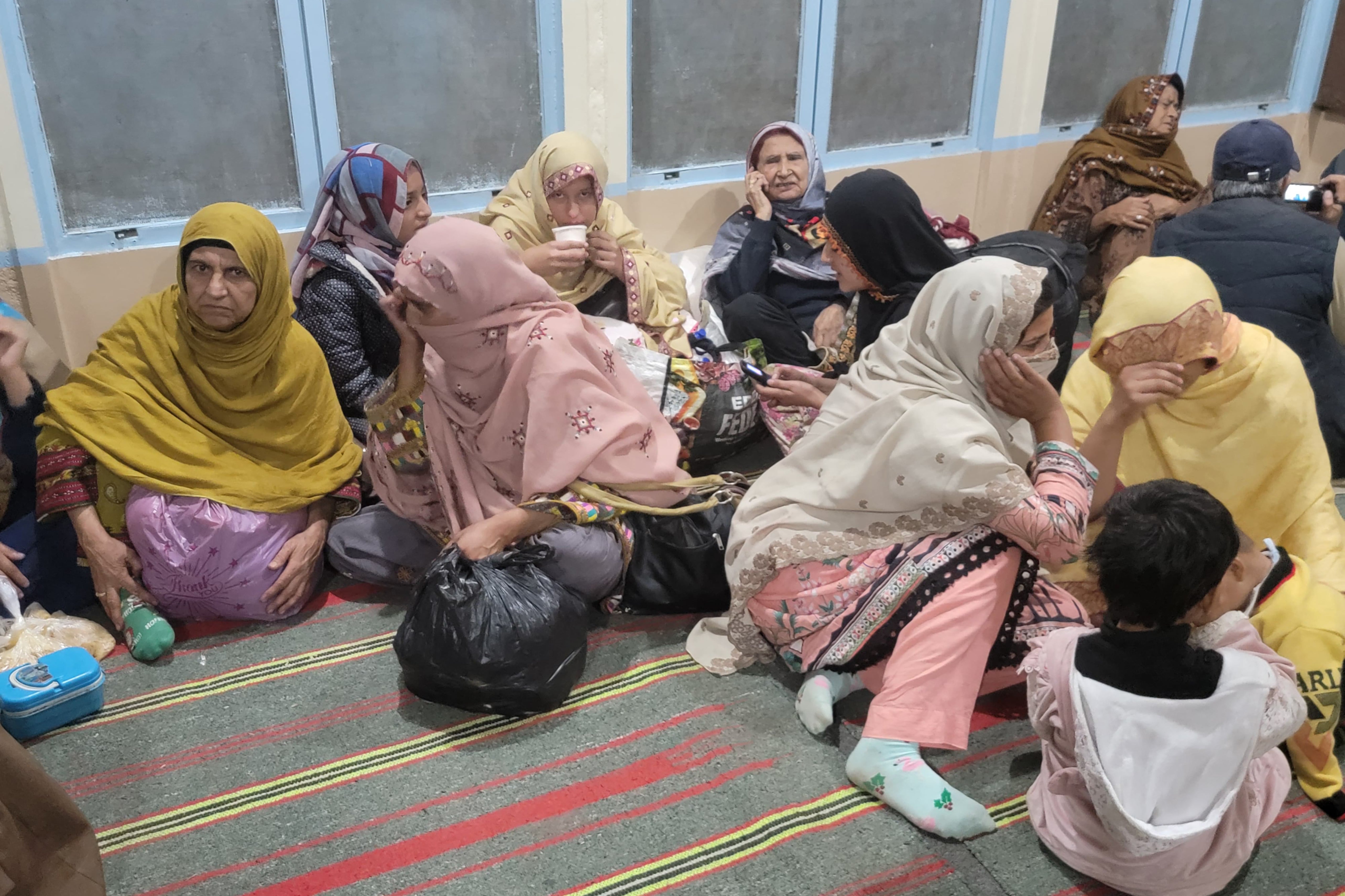 Freed passengers gather at the Mach railway station