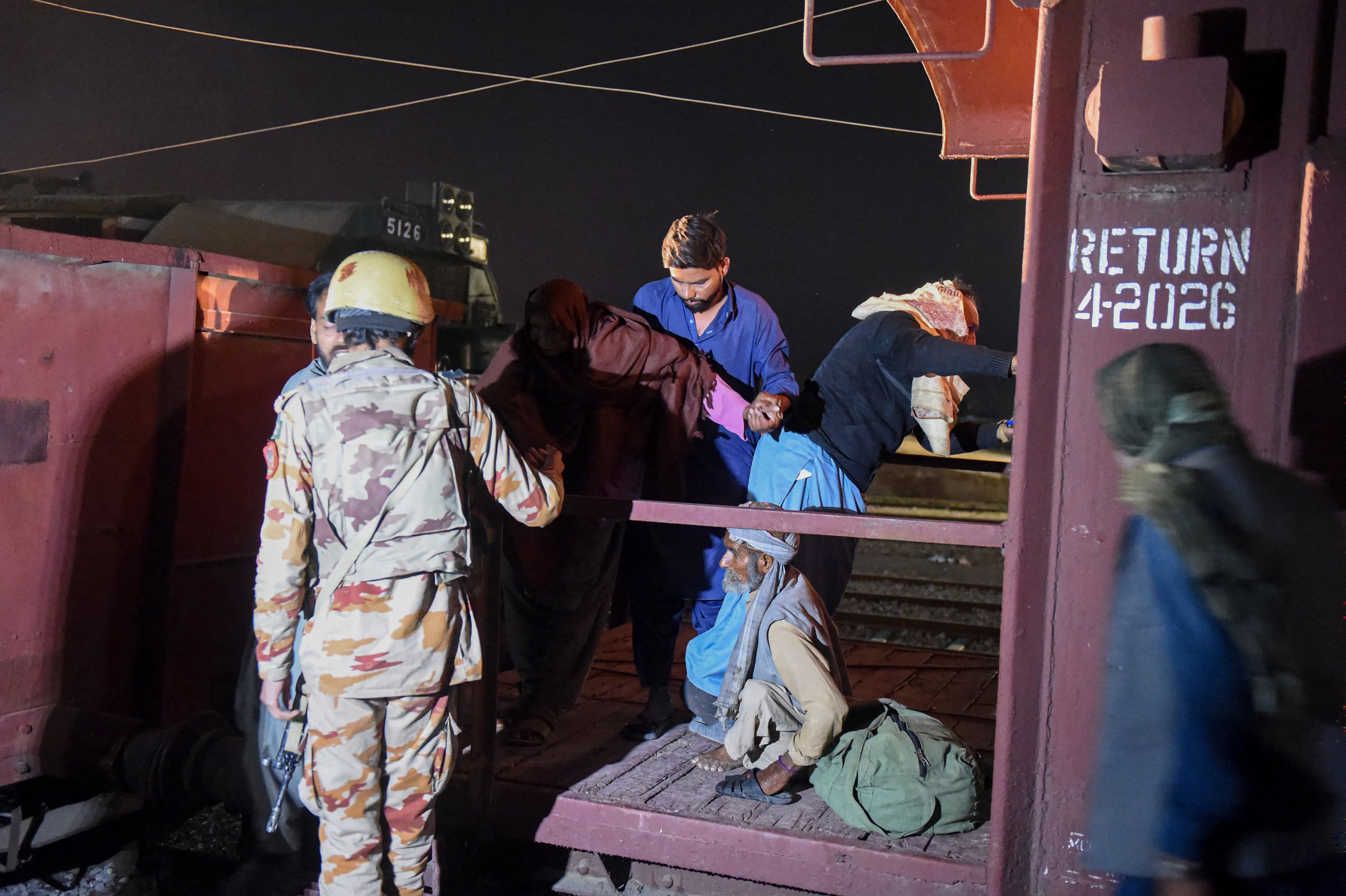 Soldier helps evacuate freed train passengers at the Mach railway station in Pakistan