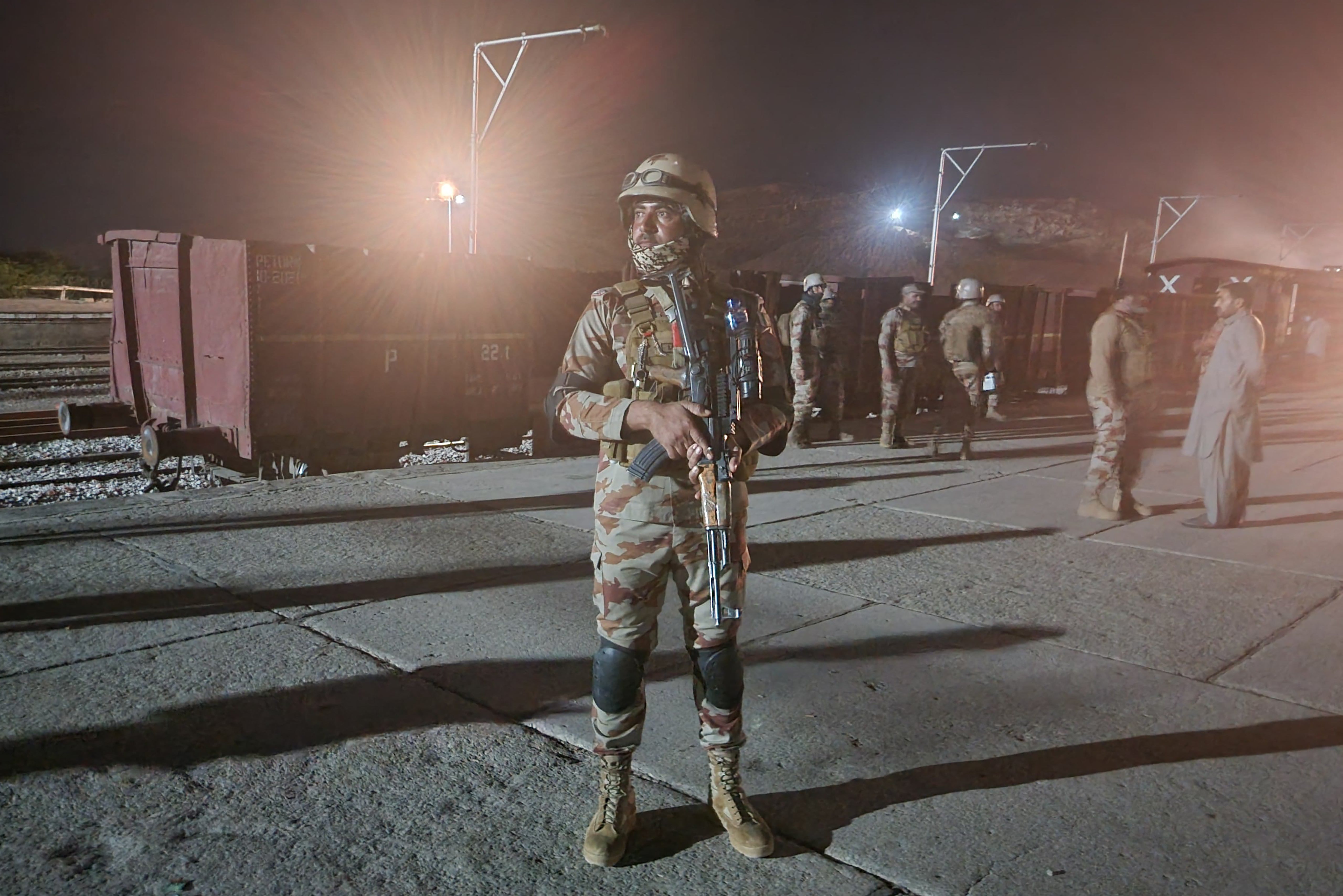 Pakistani soldiers secure the station following an operation against militants who ambushed a train on Tuesday