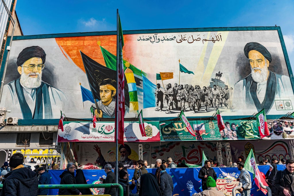 Iranians pass by a mural of Iran's leader Ayatollah Ali Khamenei and former leader Khomeini during a rally that marks the 46th anniversary of Iran's 1979 Islamic Revolution in Tehran