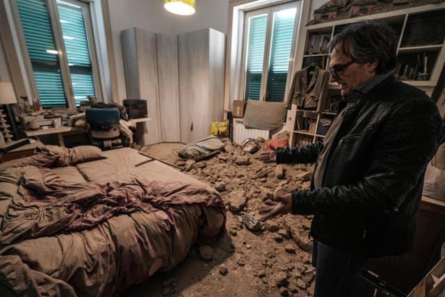 <p>A person shows the damage to their home following the 4.4 magnitude earthquake </p>