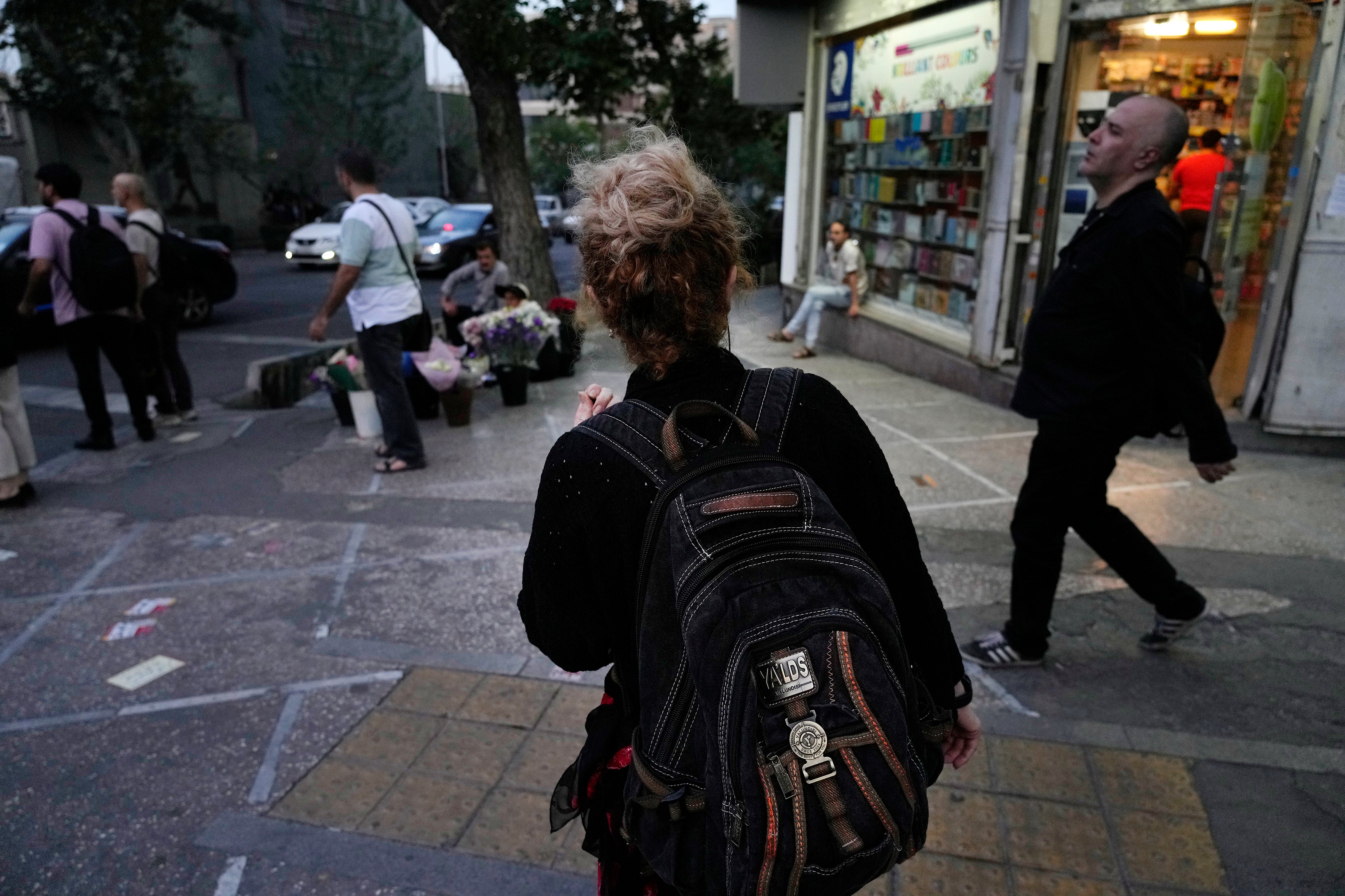 An Iranian woman, without a mandatory headscarf, or hijab, walks in downtown Tehran