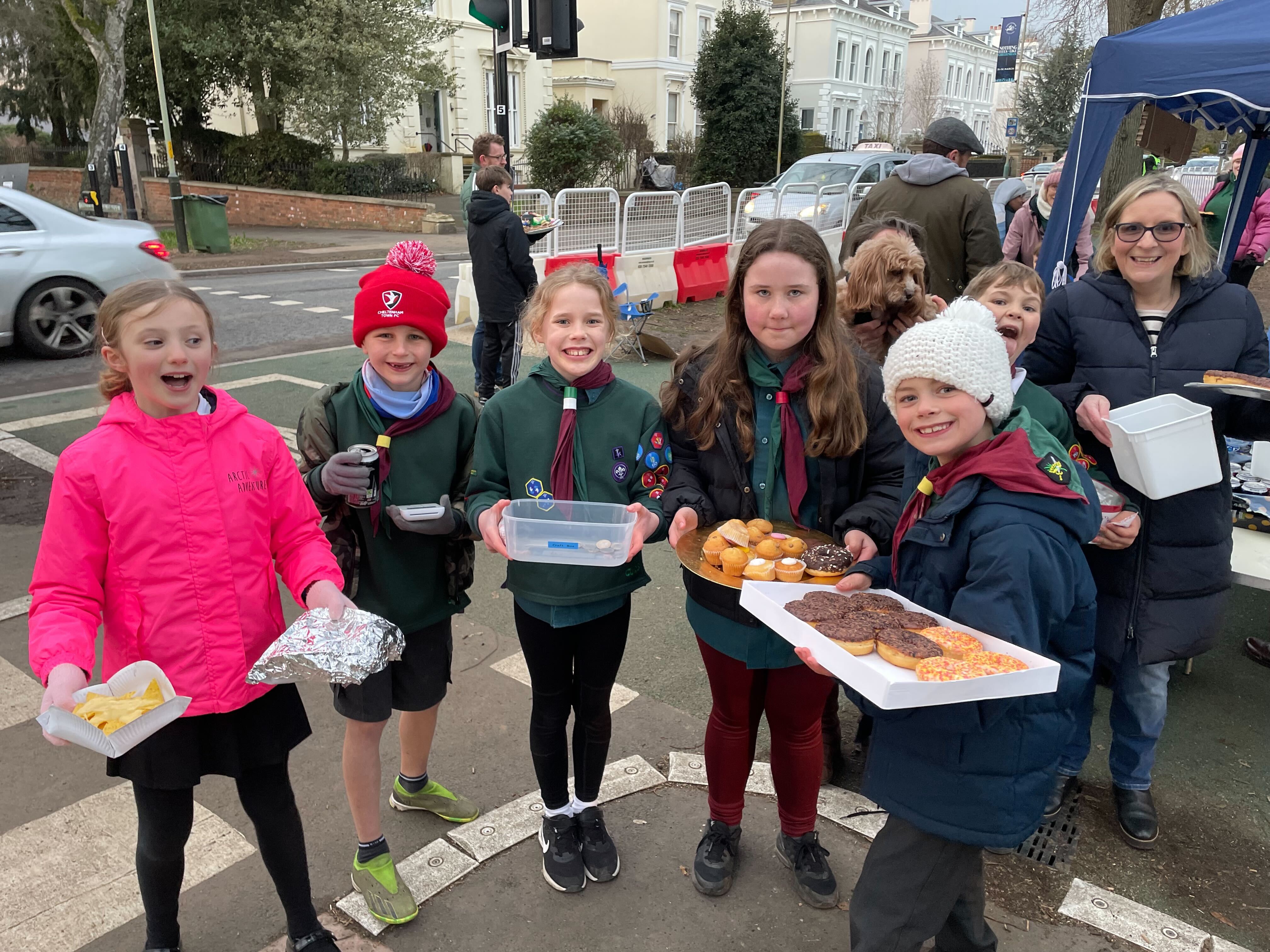 Children from a scout group sell cakes along the walkway from the racecourse to the town centre, where there is a family atmosphere following the races