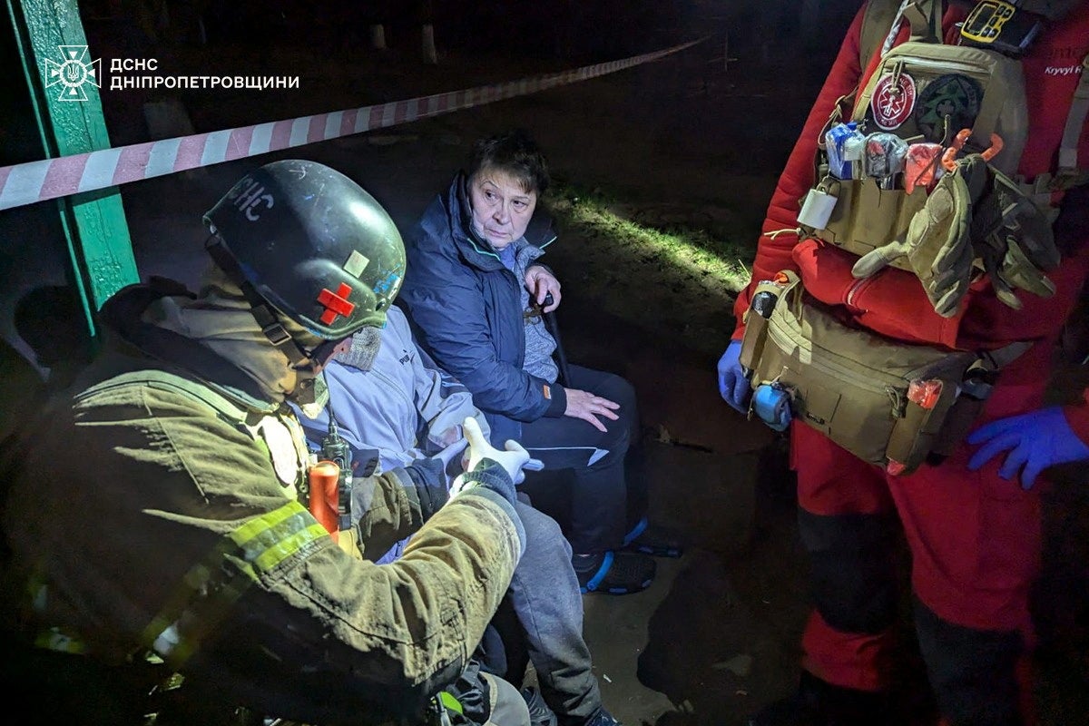 A rescuer and a medical worker treat a wounded resident