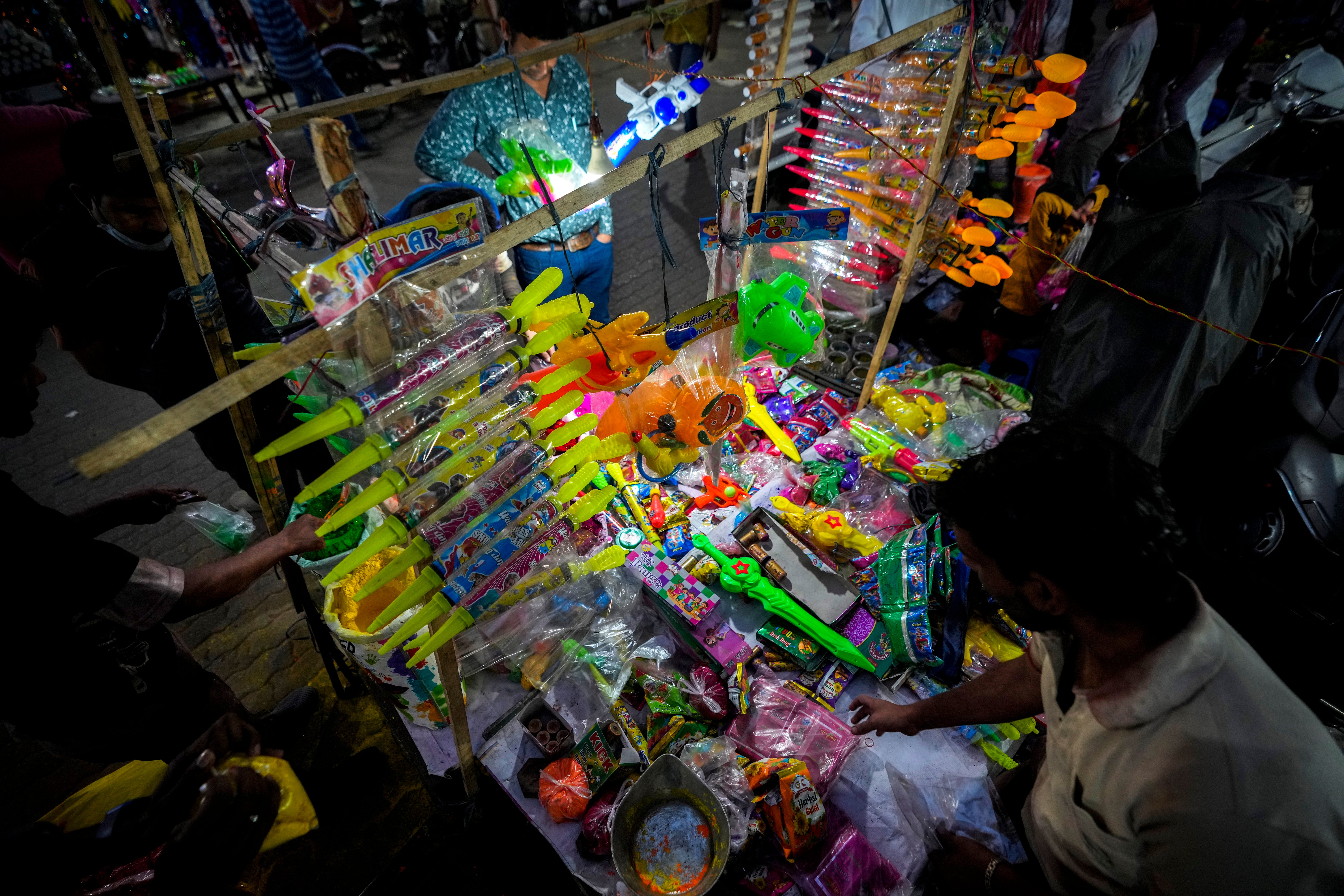 A street vendor sells water guns and coloured powders ahead of Holi festival in the northeastern state of Guwahati