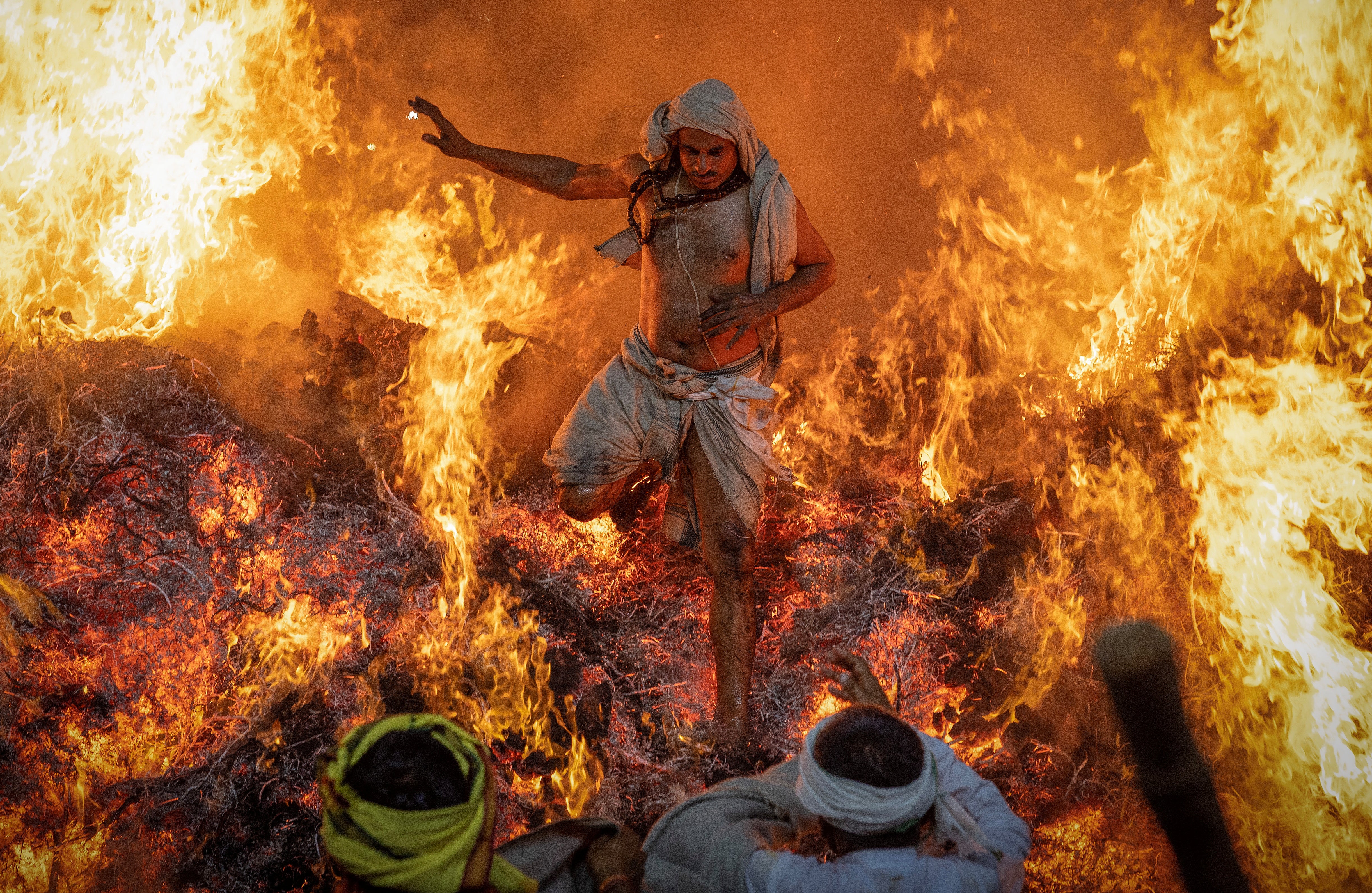 A Hindu priest named Sanju jumps out of a fire during a Holi ritual known as 'Holika Dahan’ at Phalen village near the northern city of Mathura