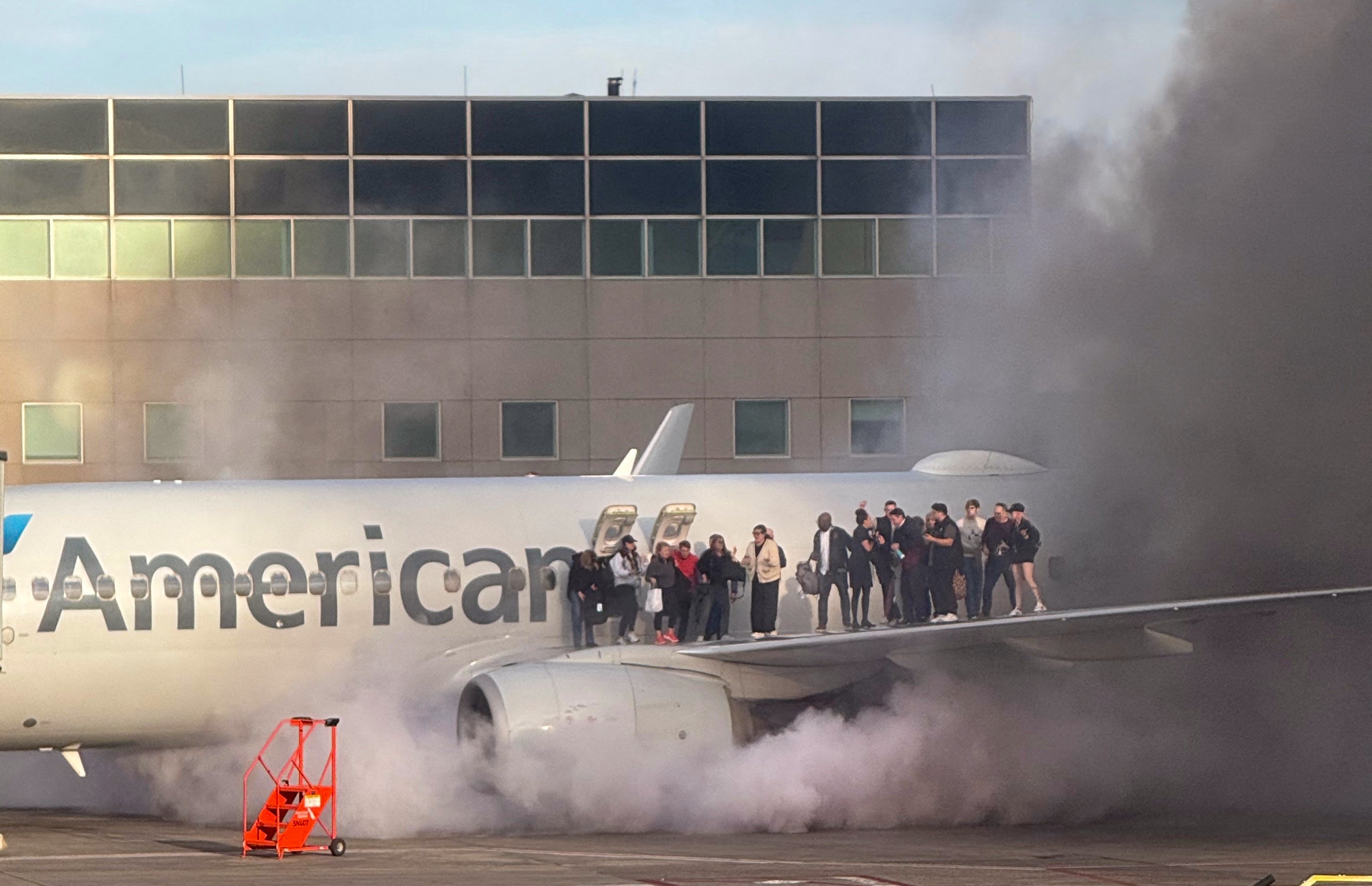 Passengers stand on the wing of the American Airlines Boeing 737-800