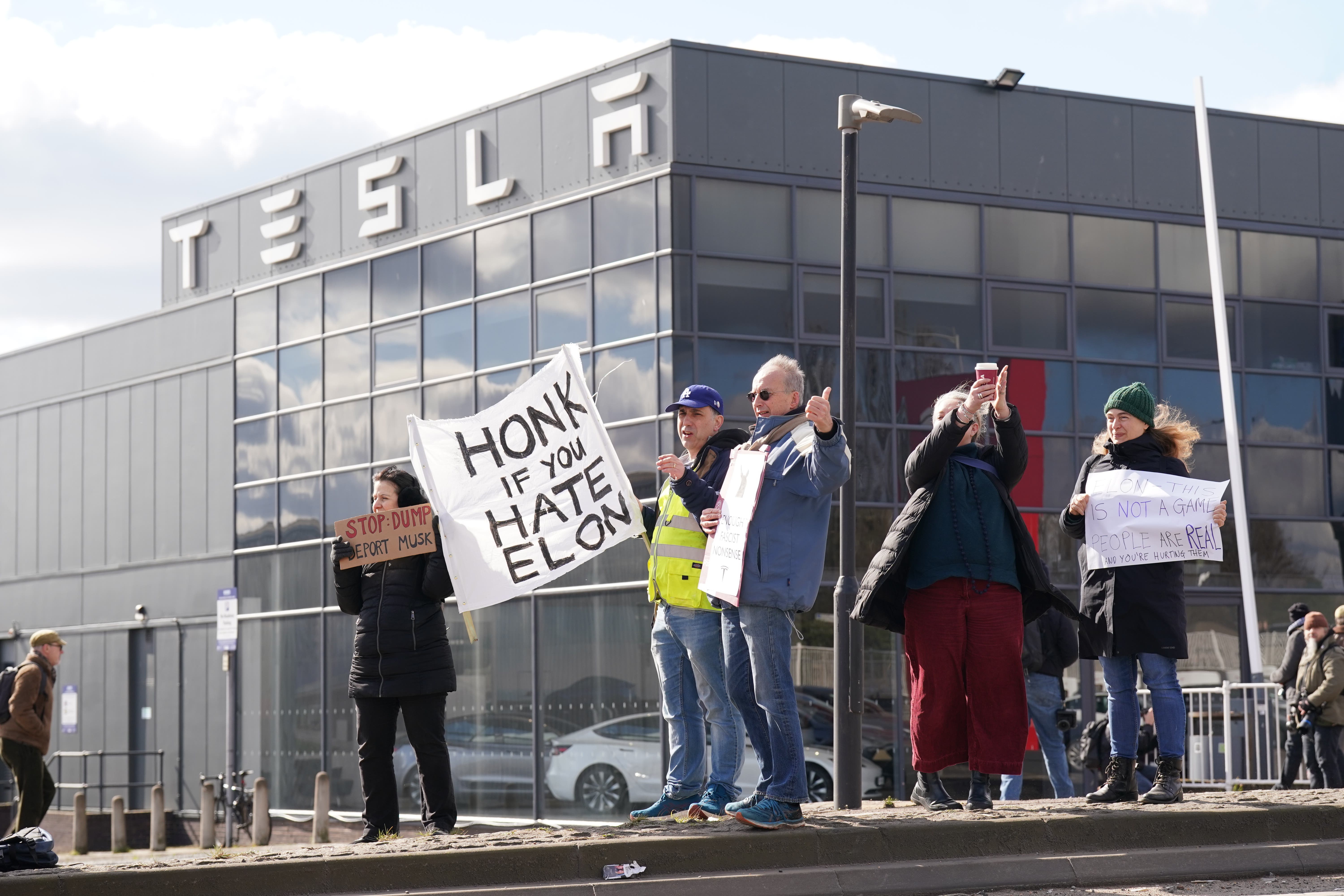 A small group of protesters gathered at a Tesla dealership, where they called on people to boycott Elon Musk’s electric car maker (Stefan Rousseau/PA)