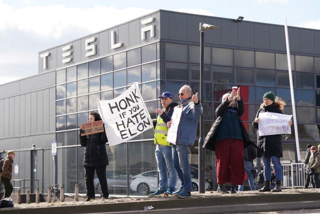 A small group of protesters gathered at a Tesla dealership, where they called on people to boycott Elon Musk’s electric car maker (Stefan Rousseau/PA)