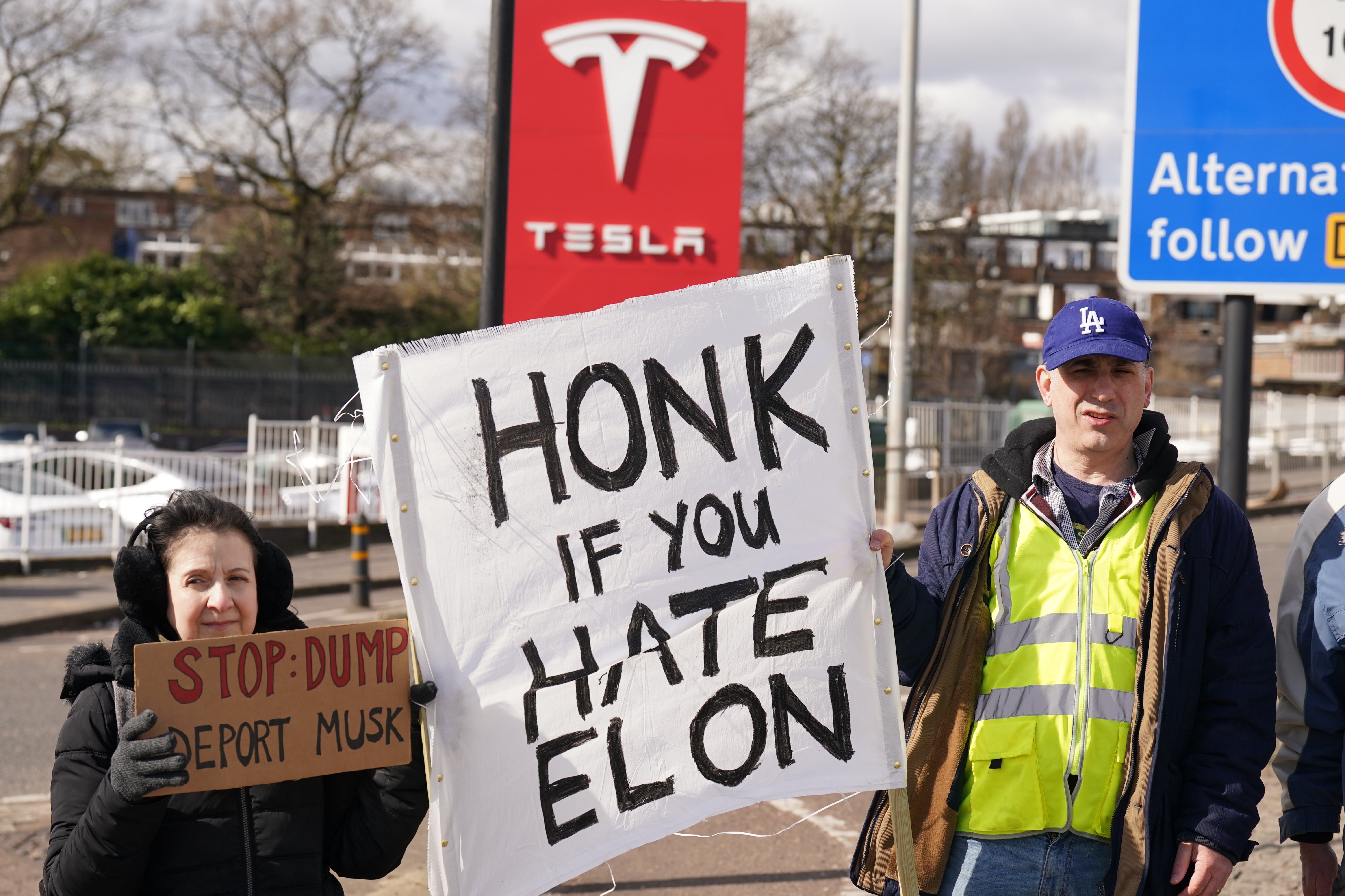 <p>Protesters held signs that said ‘Honk if you hate Elon’ (Stefan Rousseau/PA)</p>