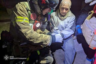 A rescuer treats a wounded resident on the site of a Russian rocket strike in Kryvyi Rih