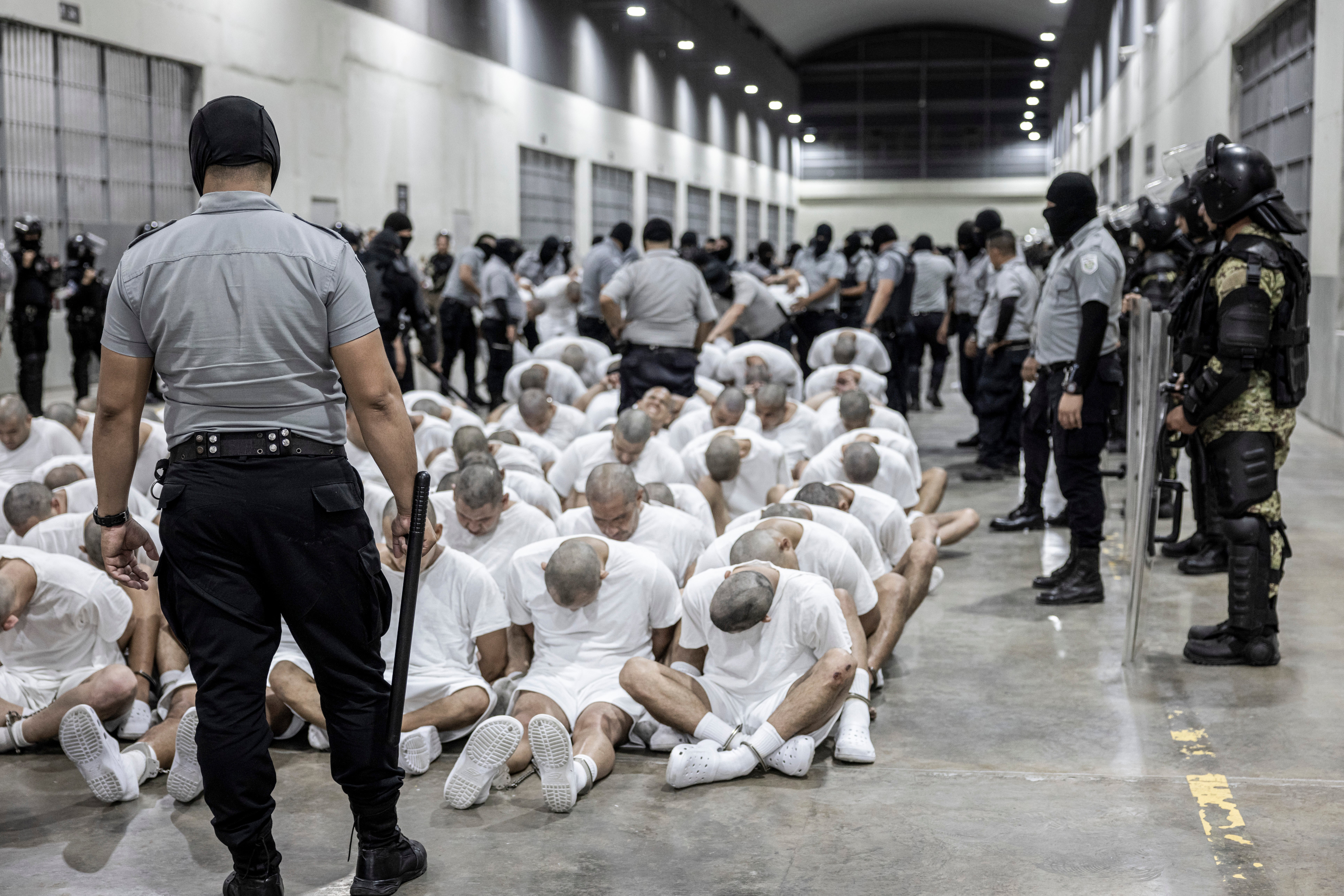 In this photo provided by El Salvador's presidential press office, a prison guard transfers deportees from the U.S., alleged to be Venezuelan gang members, to the Terrorism Confinement Center in Tecoluca, El Salvador on March 16, 2025