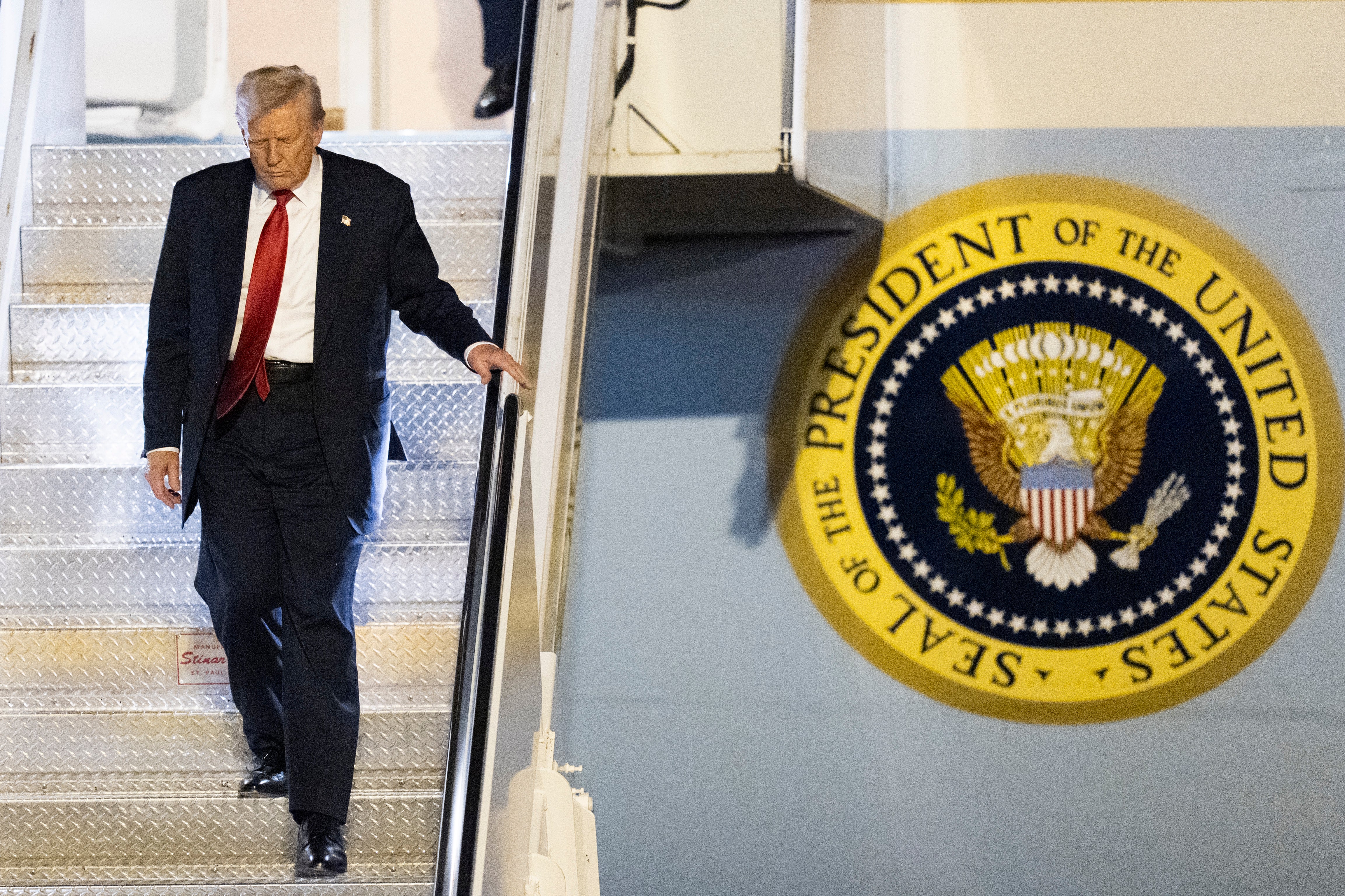 President Donald Trump descends the steps of Air Force One.