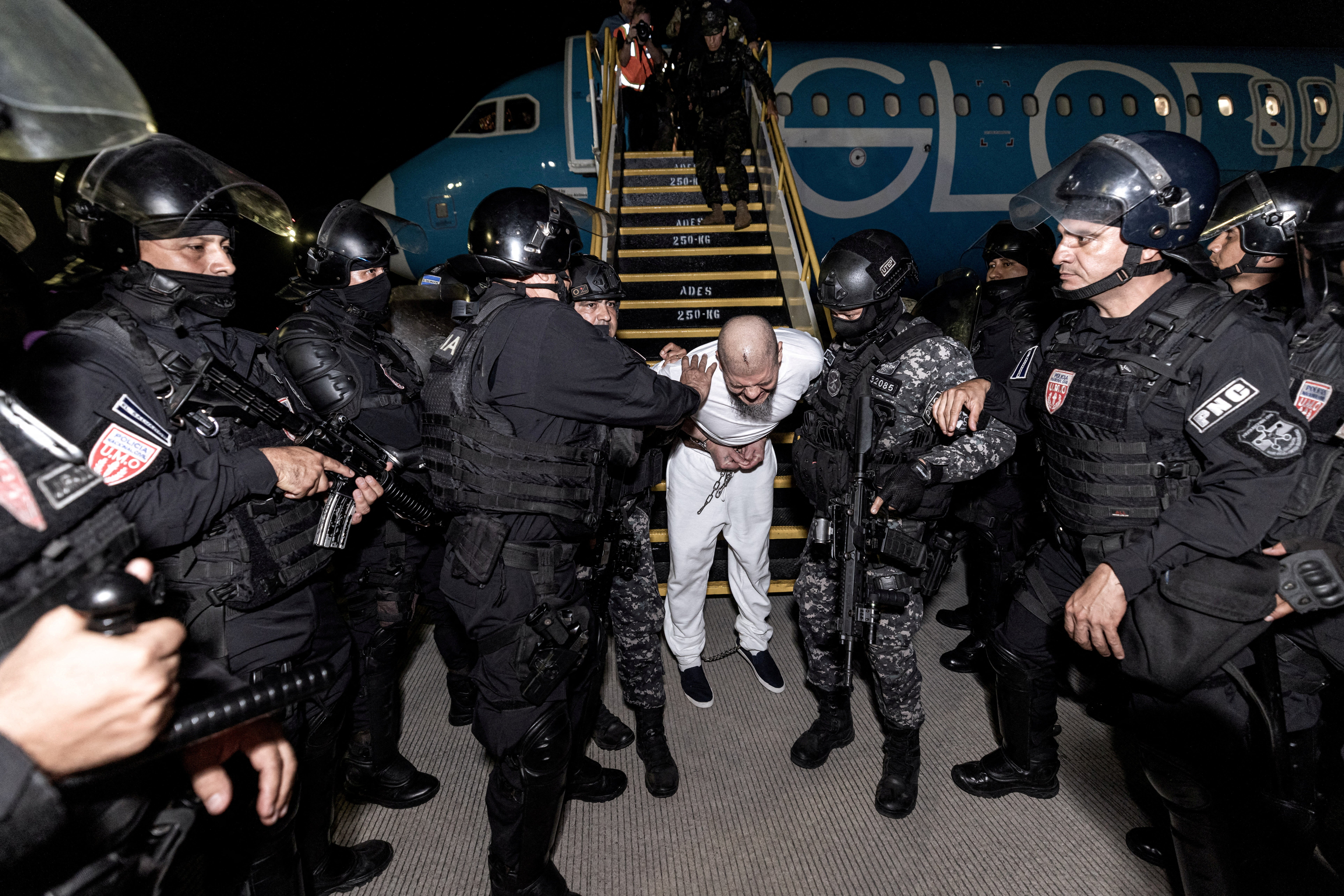 Salvadoran police officers escort alleged members of the Venezuelan gang Tren de Aragua recently deported by the U.S. government to be imprisoned in the Terrorism Confinement Center (CECOT) prison in a photo shared by El Salvador officials