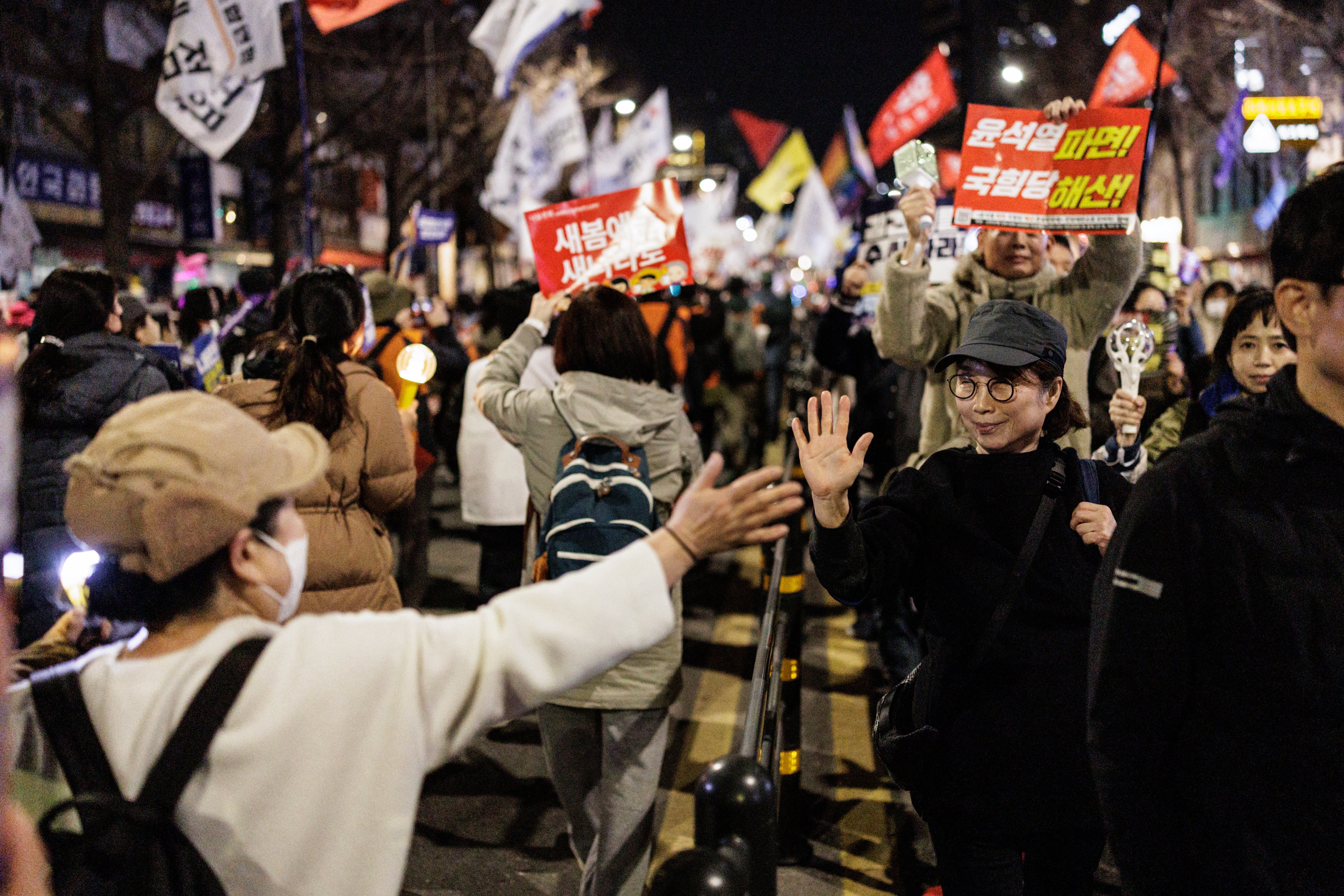 Protesters march past each other on the same street during a demonstration against impeached South Korean president Yoon Suk Yeol, in Seoul on 15 March 2025