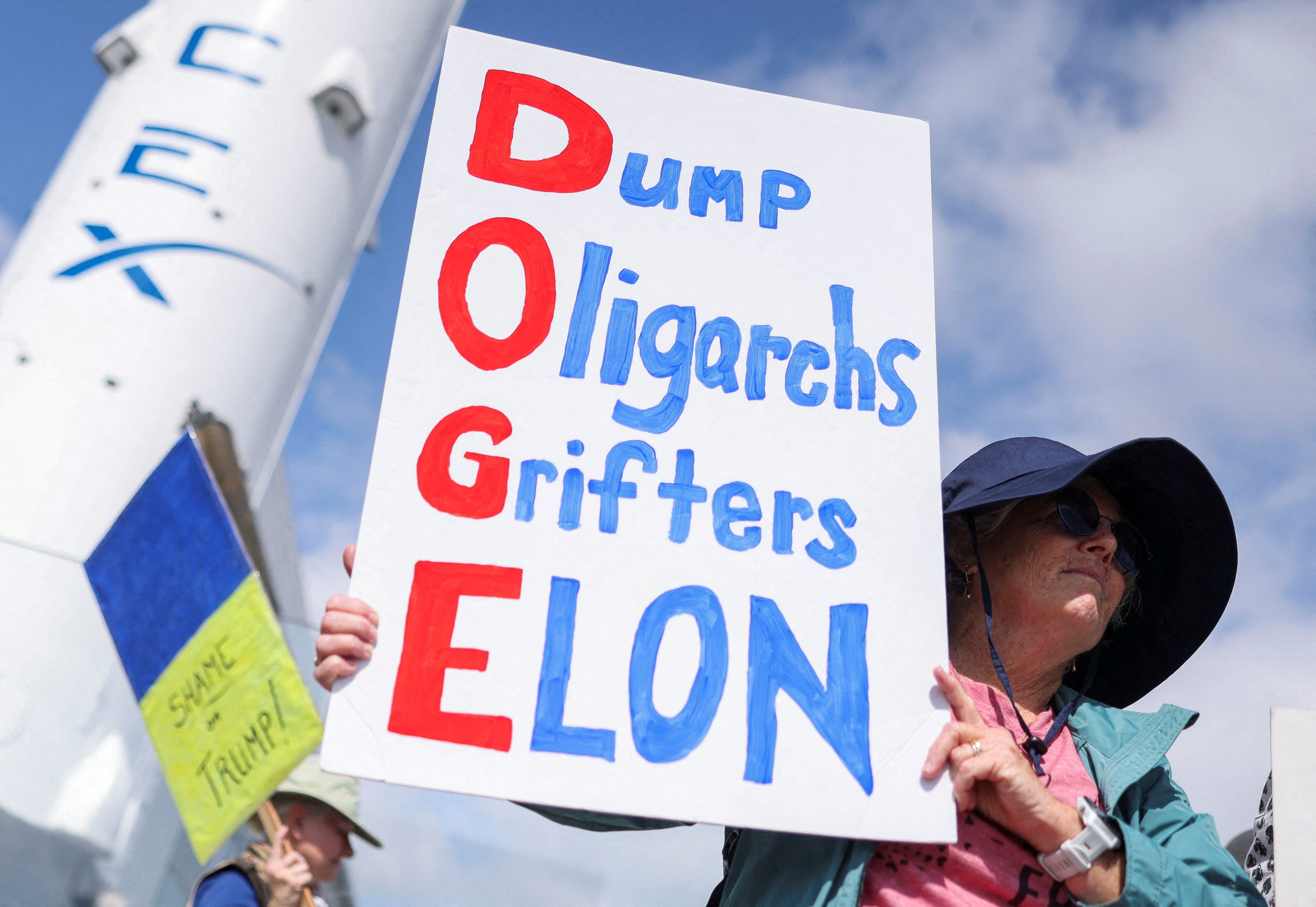 A demonstrator holds a sign outside Elon Musk’s SpaceX facility in California on March 1 as protesters across the country blast the billionaire’s DOGE cuts