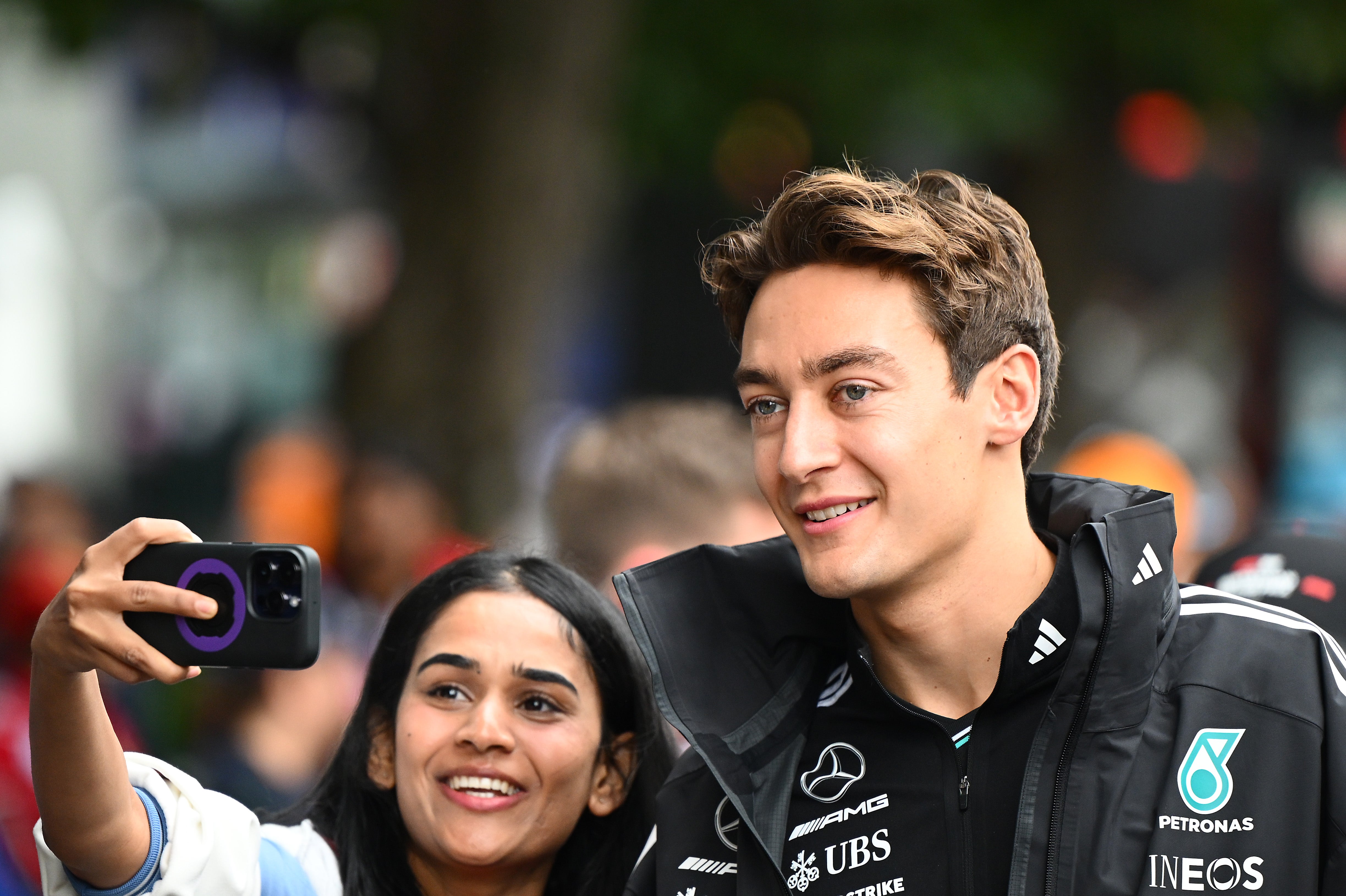 A fan takes a selfie with Mercedes driver George Russell