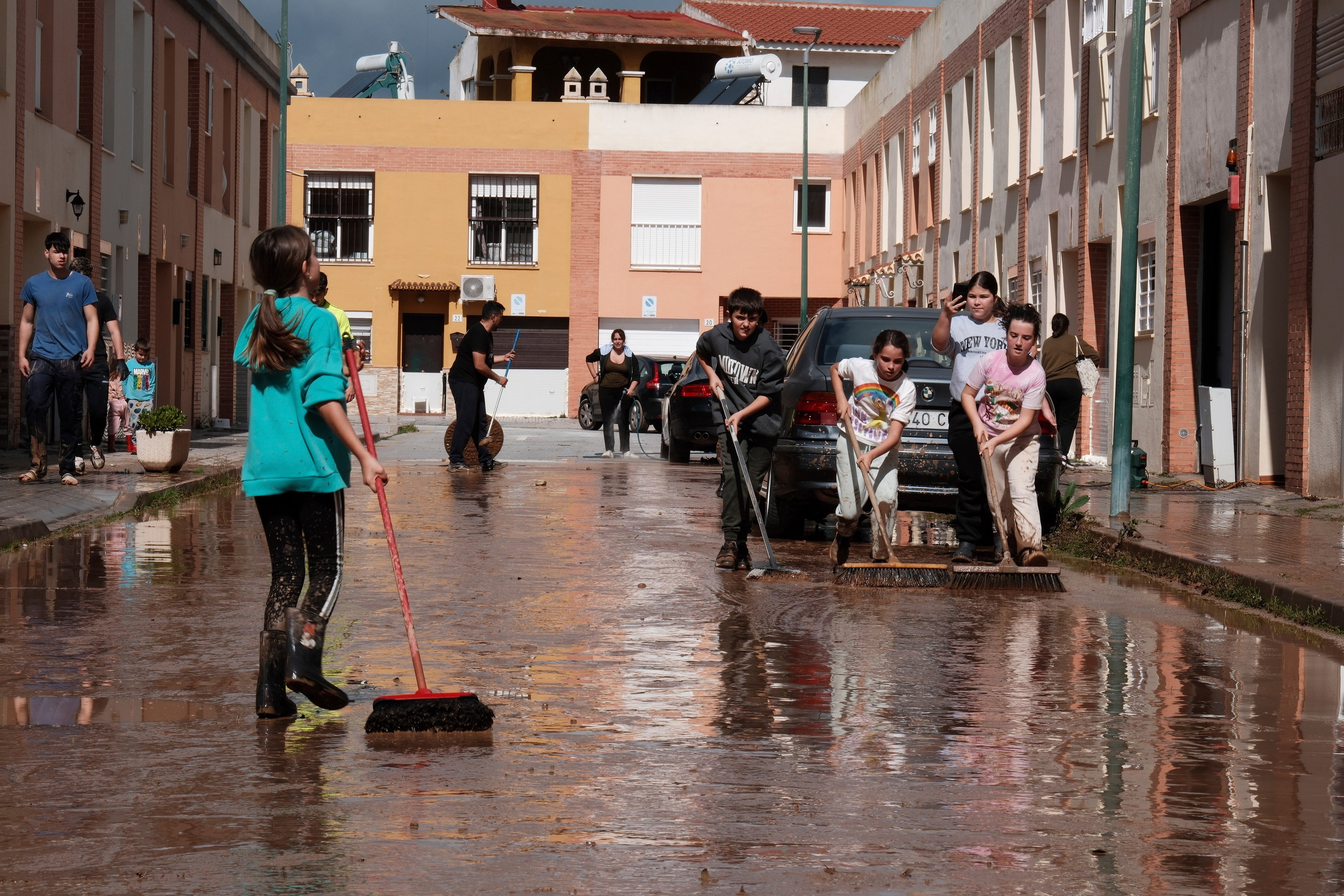 Residents clear mud from the streets after heavy rains in Campanillas, Malaga