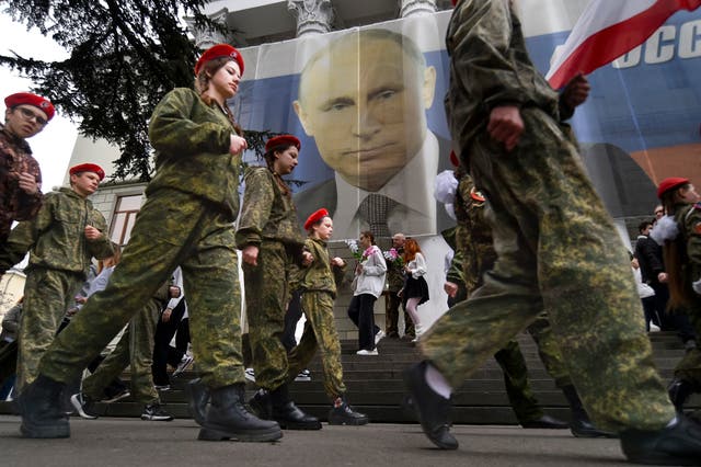 <p>Youths mark the ninth anniversary of the annexation of Crimea from Ukraine with a banner reading, ‘Russia doesn't start wars, it ends them,’ in 2023</p>