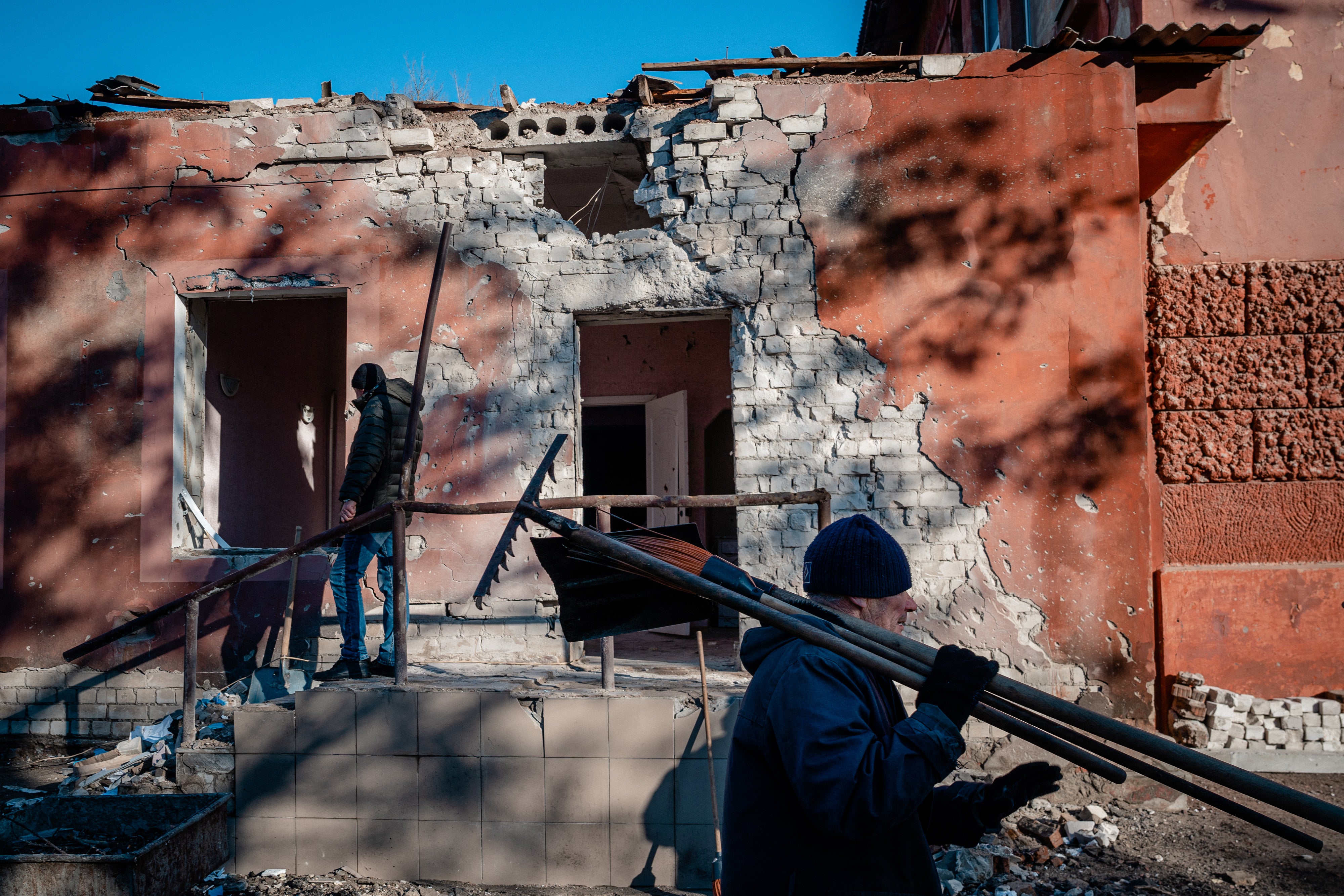 Workers clean up debris after Russian shelling of the hospital maternity unit in Kherson