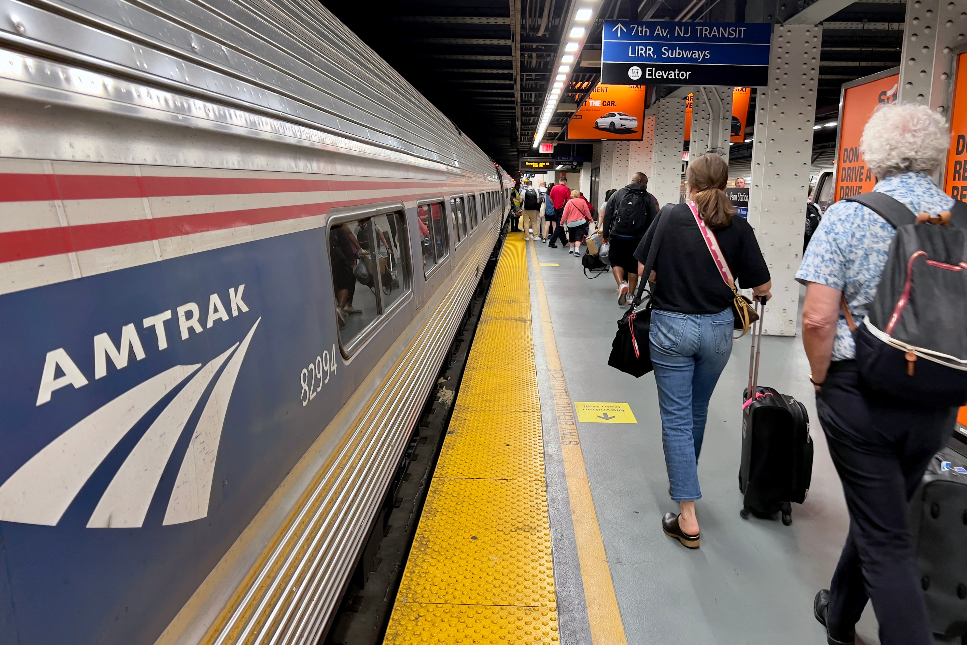 Passengers leave an Amtrak train at New York City's Penn Station. Amtrak's CEO has stepped down after Elon Musl called for the rail service to be privatized