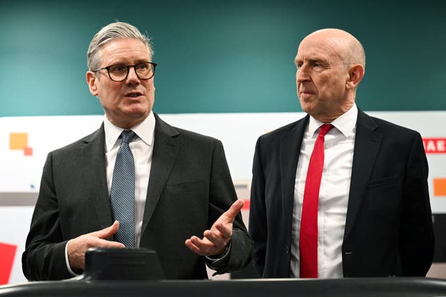 Prime Minister Sir Keir Starmer (left) and Defence Secretary John Healey (right) meet with BAE system apprentices as they look at a submarine model during their visit to BAE Systems Submarines shipyard in Barrow-in-Furness, Cumbria, north west England (PA)