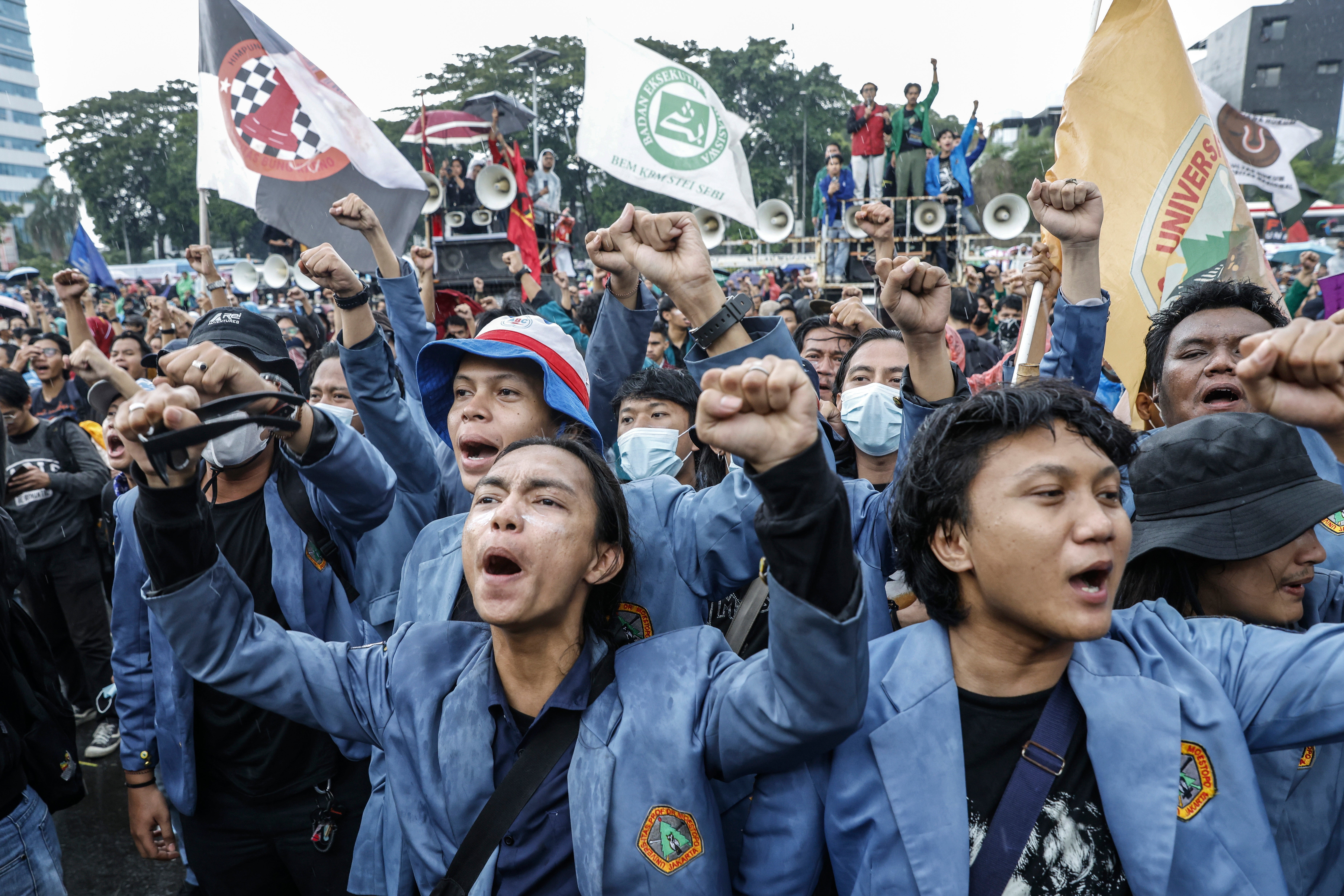 Demonstrators shout slogans during a protest against the revision of the country's military law outside the parliament building in Jakarta