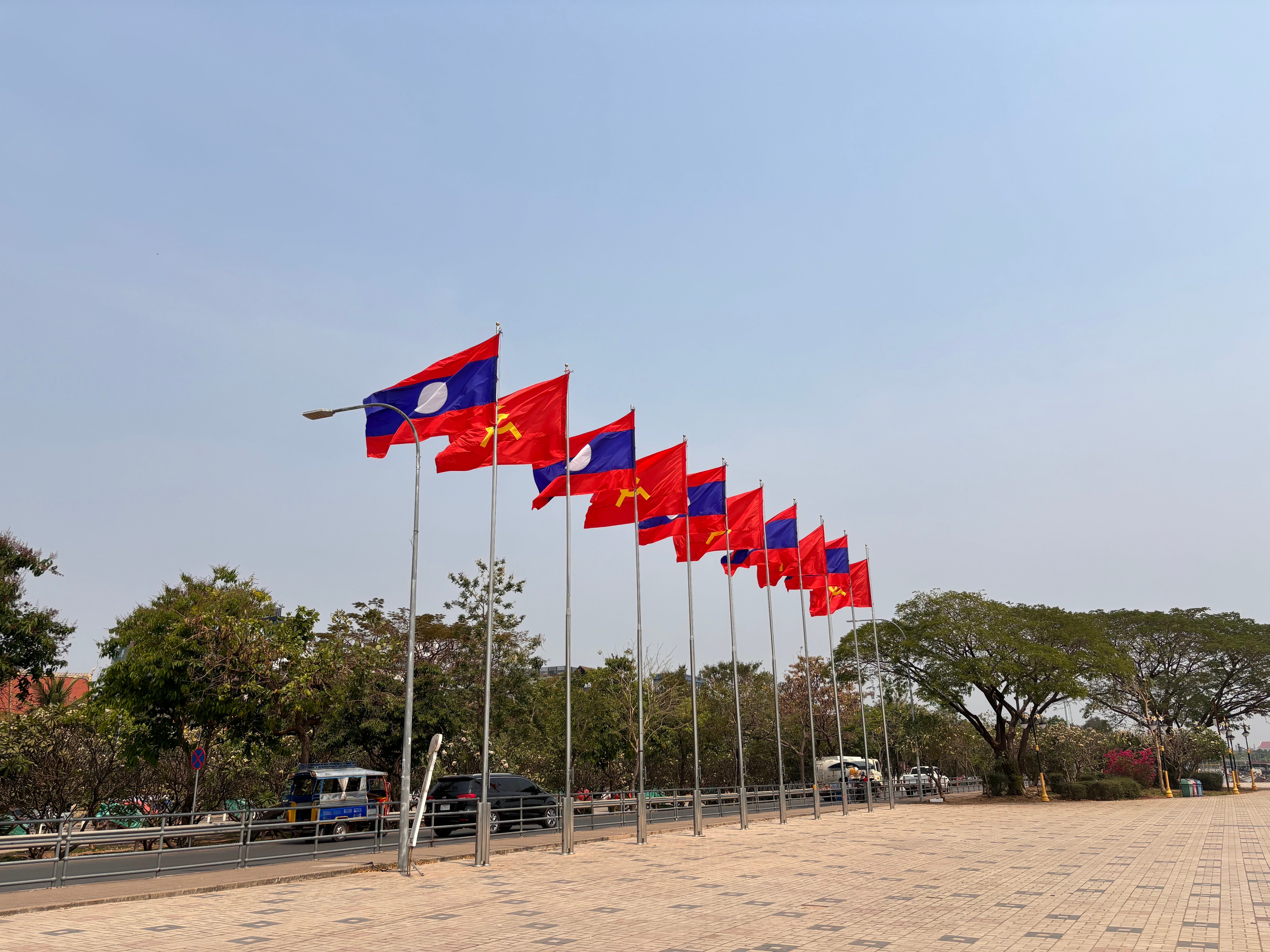 Flags of Lao PDR and the Lao People’s Revolutionary Party by the Mekong River in Vientiane