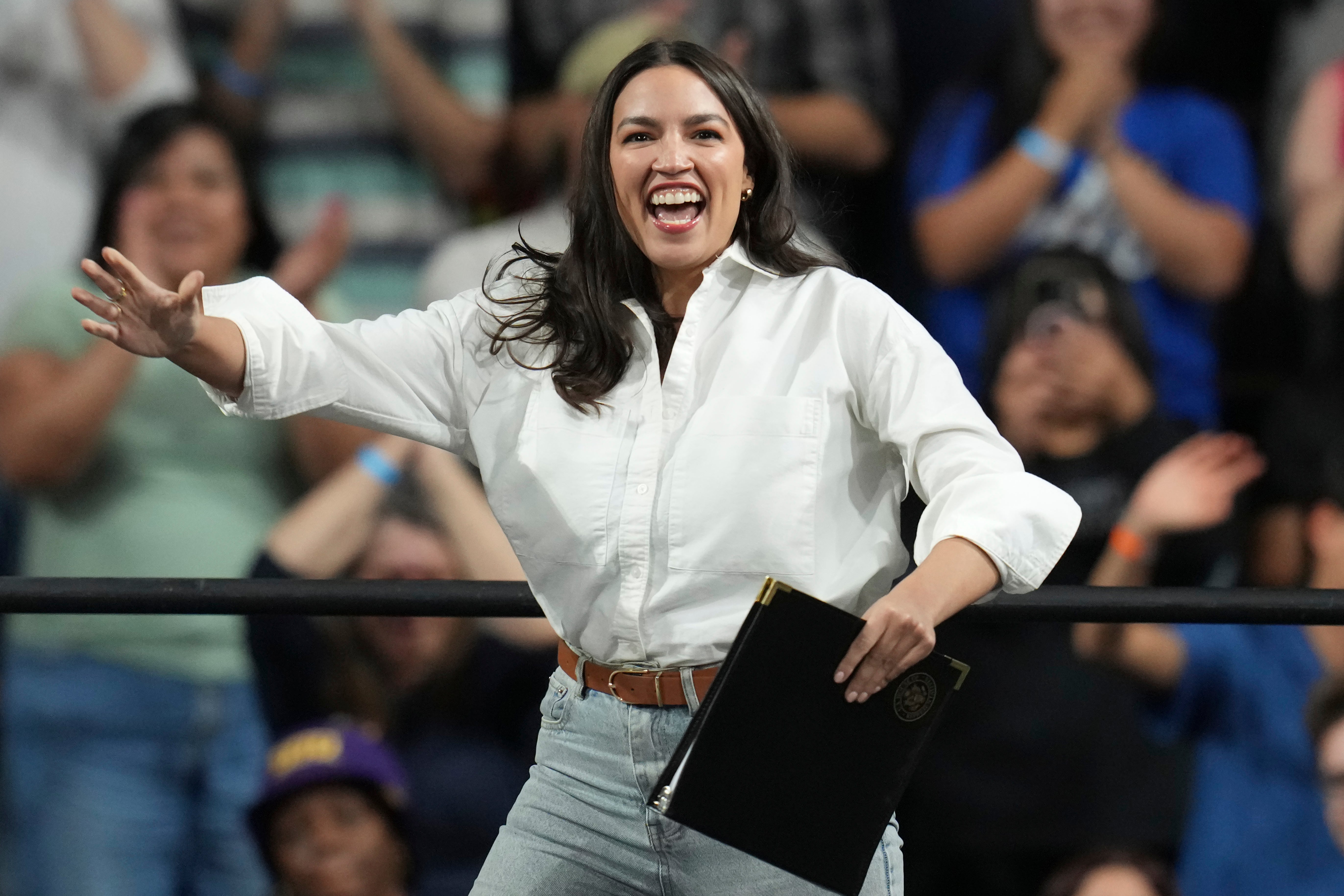 A revved-up New York Rep. Alexandria Ocasio-Cortez arrives to speak during a 'Fighting Oligarchy' tour event at Arizona State University in Tempe on Thursday