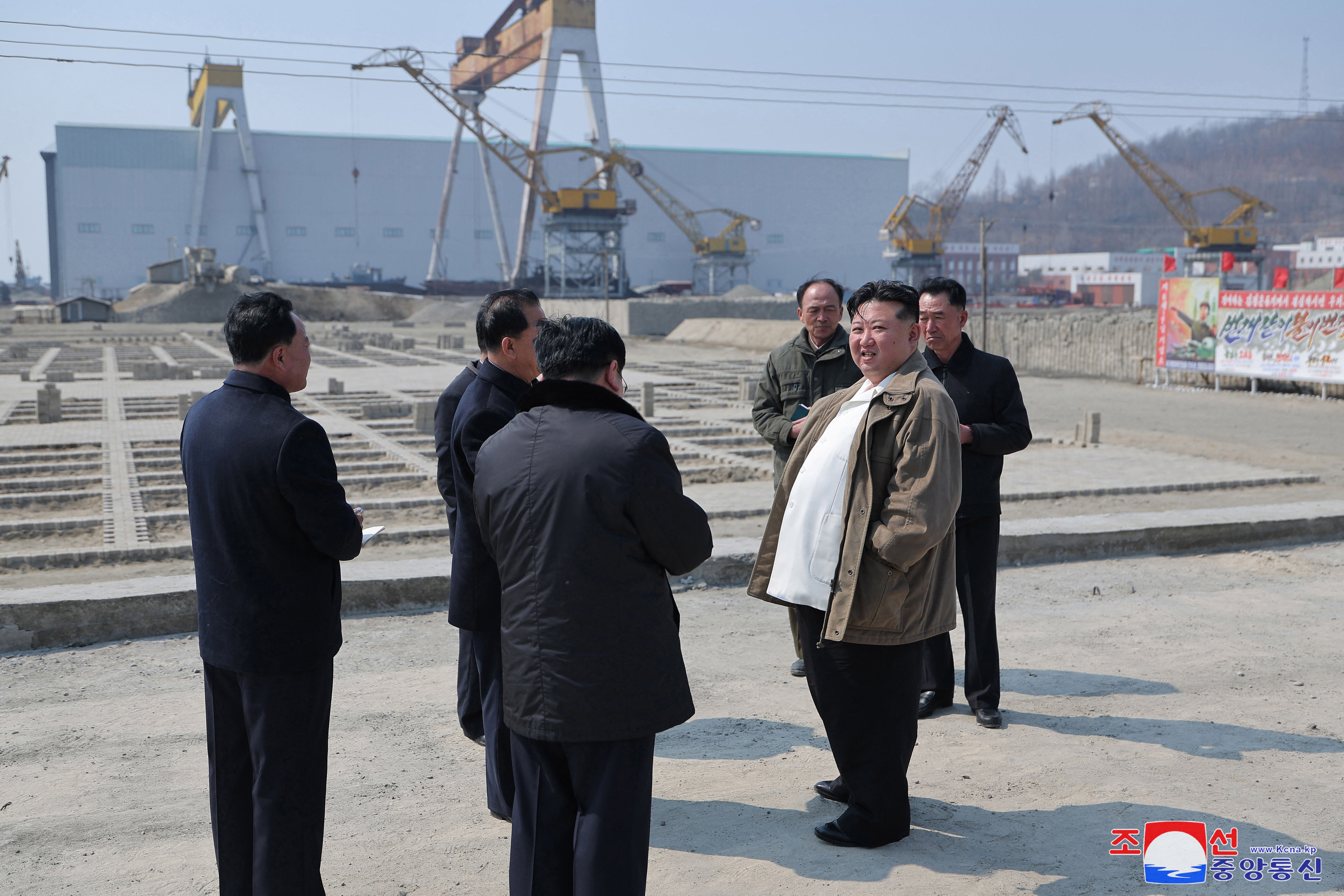 This picture taken on March 20, 2025 shows North Korean leader Kim Jong Un (R) inspecting the Nampo Shipyard in Nampo