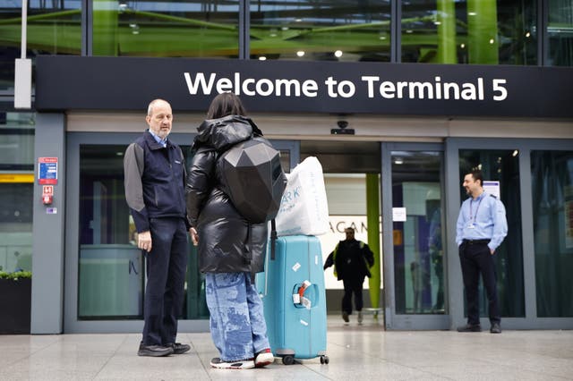 <p>Passengers wait outside Heathrow Aiport</p>