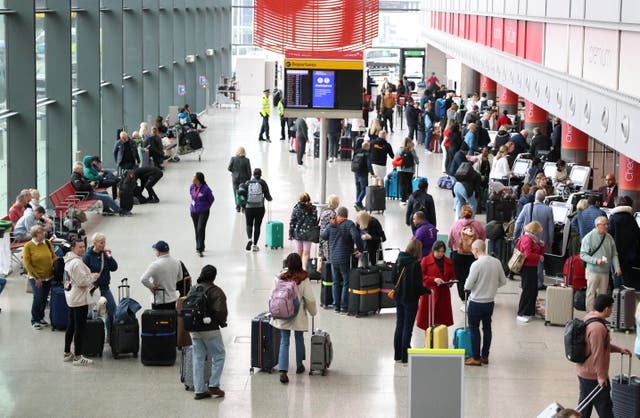 <p>Passengers stand in queues at Heathrow on Saturday</p>