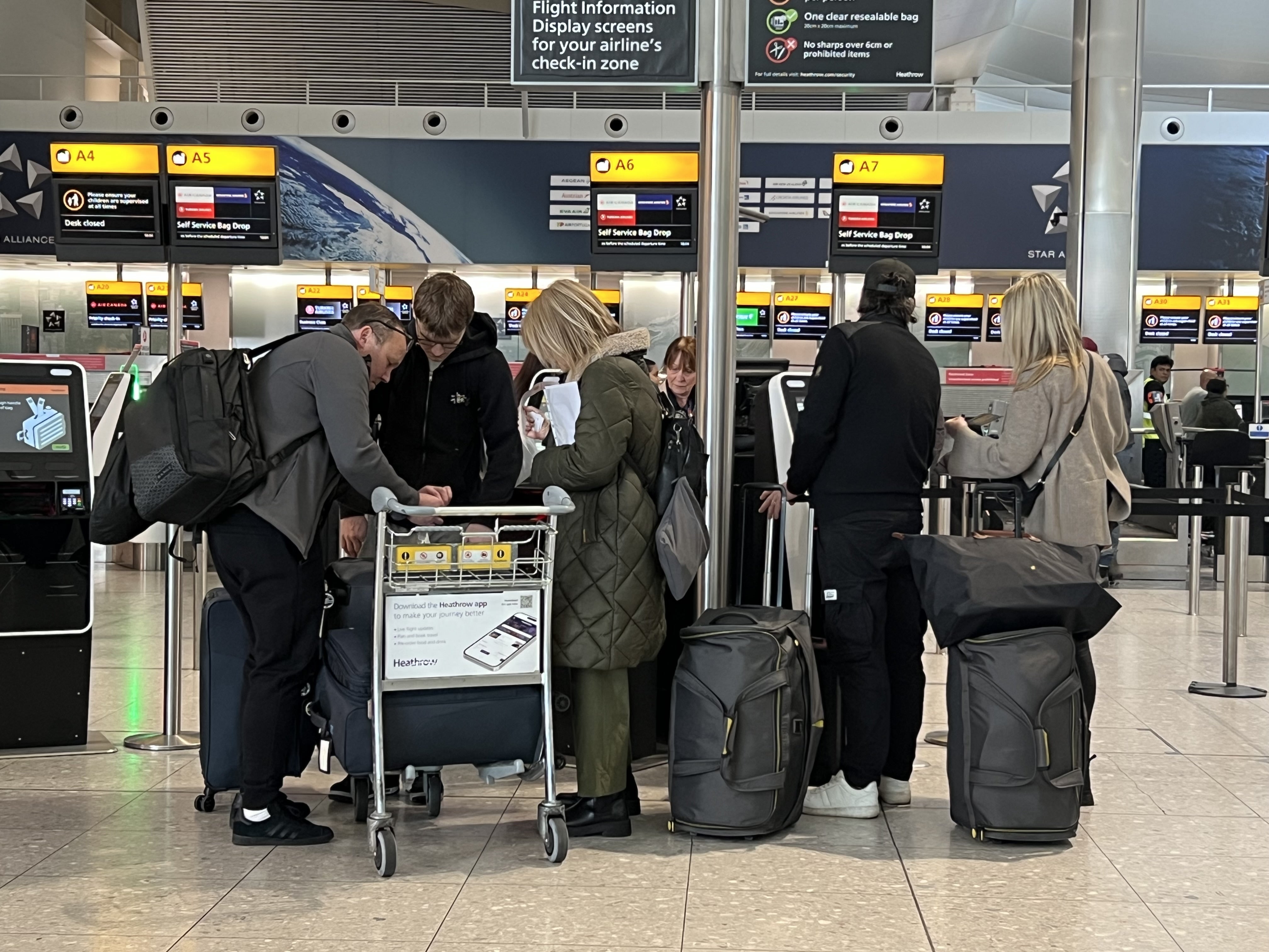 Passengers queue at a check-in desk at Heathrow Terminal 2 in London