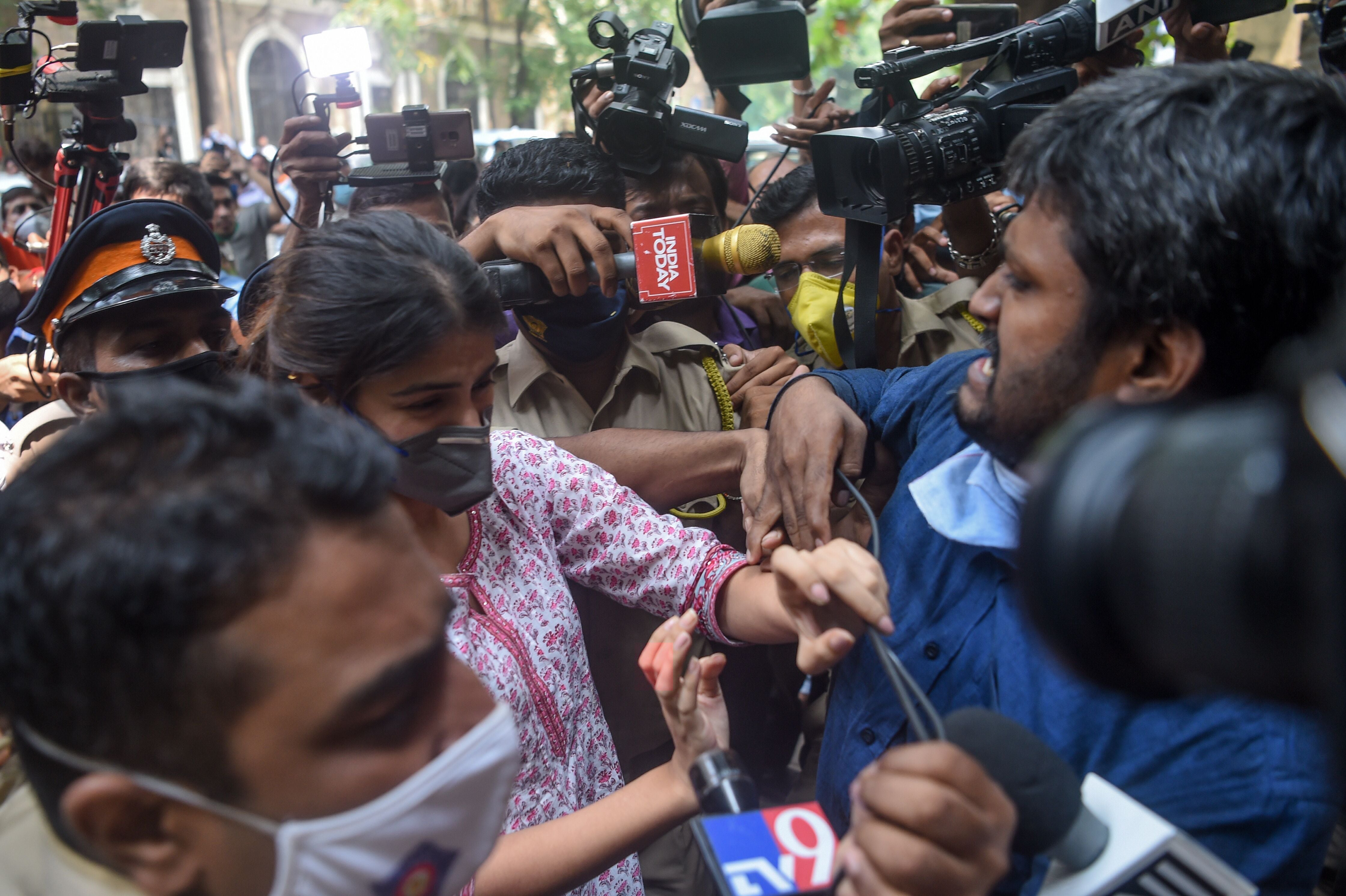 Bollywood actress Rhea Chakraborty (C) struggles with media representatives gathering as she arrives at the Narcotics Control Bureau (NCB) office for enquiry regarding Sushant Singh Rajput case, in Mumbai on 6 September 2020