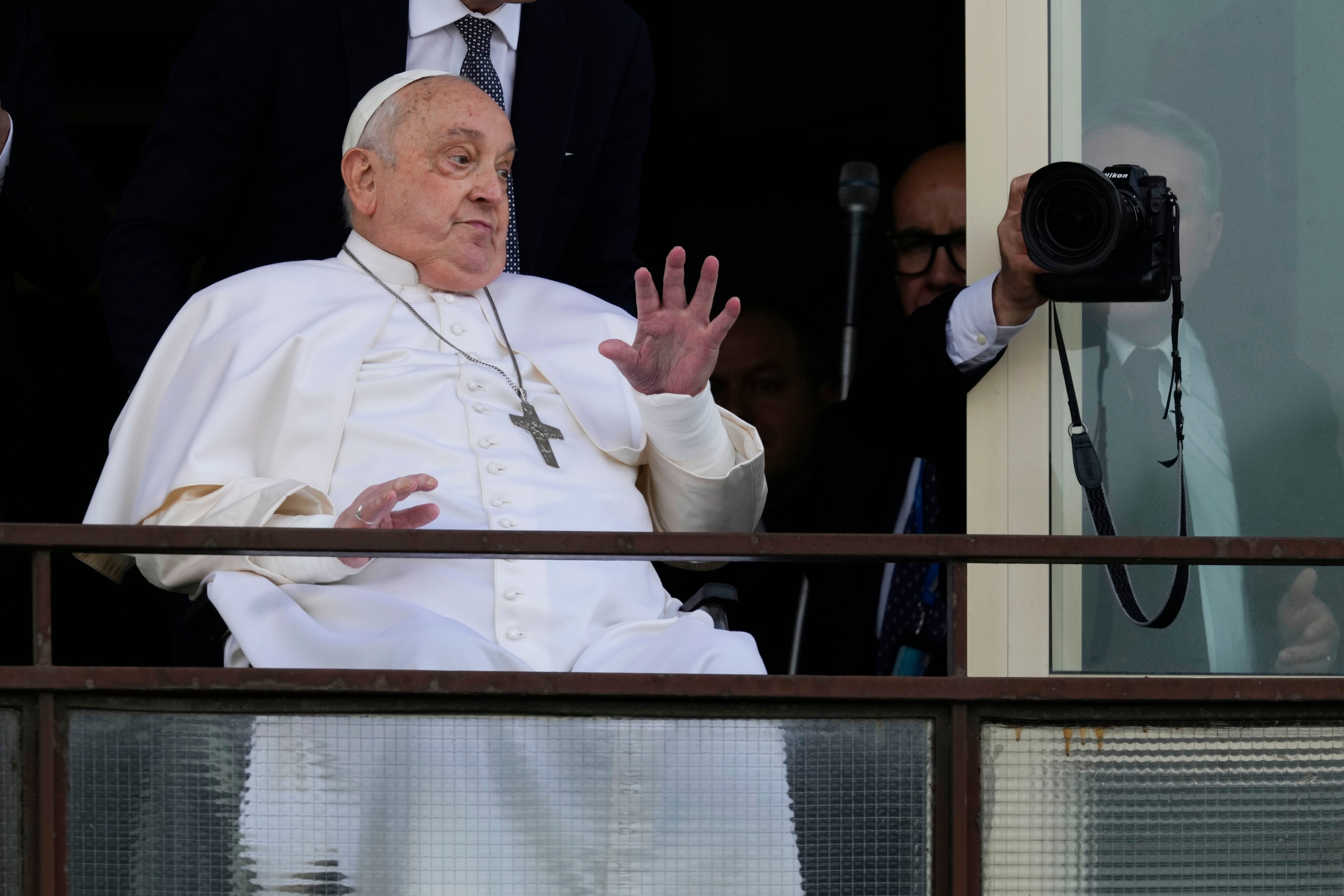 Pope Francis waves from the balcony of the Gemelli hospital before returning home to the Vatican on Sunday