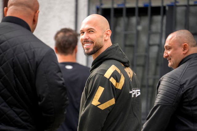 <p>Andrew Tate, center, arrives at a police station to checking in as part of his judicial control, which requires him to appear before judicial authorities in Romania when summoned, after returning from the United States, in Voluntari, Romania, Monday, March 24, 2025. (AP Photo/Vadim Ghirda)</p>