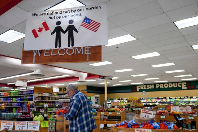 <p>A shopper at the Point Roberts International Marketplace inspects a bag of oranges</p>