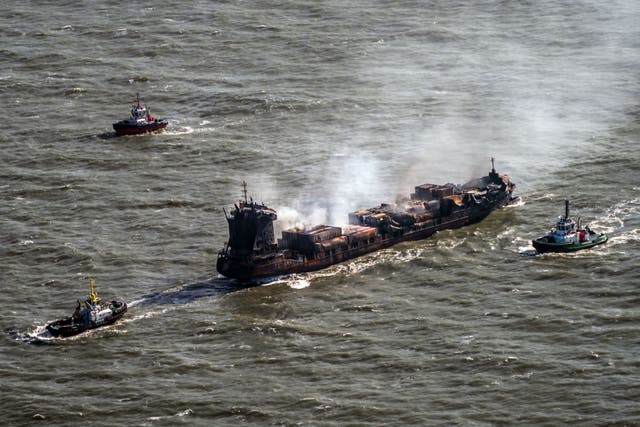 Tug boats shadow the Solong container ship as it drifts in the Humber Estuary, off the coast of East Yorkshire, following a collision with the MV Stena Immaculate oil tanker (Danny Lawson/PA)