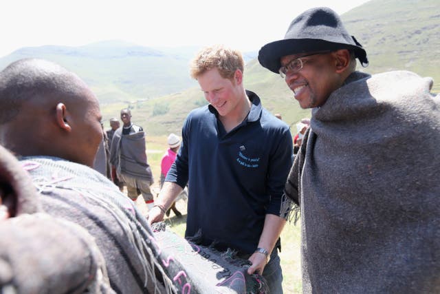 <p>Prince Harry looks at a traditional Lesothan blanket with Prince Seeiso of Lesotho at the site of a Sentebale Mateanong Herd Boy School </p>