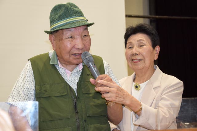<p>This photo taken on 29 September 2024 shows Iwao Hakamada speaking as his then 91-year-old sister Hideko holds the microphone</p>