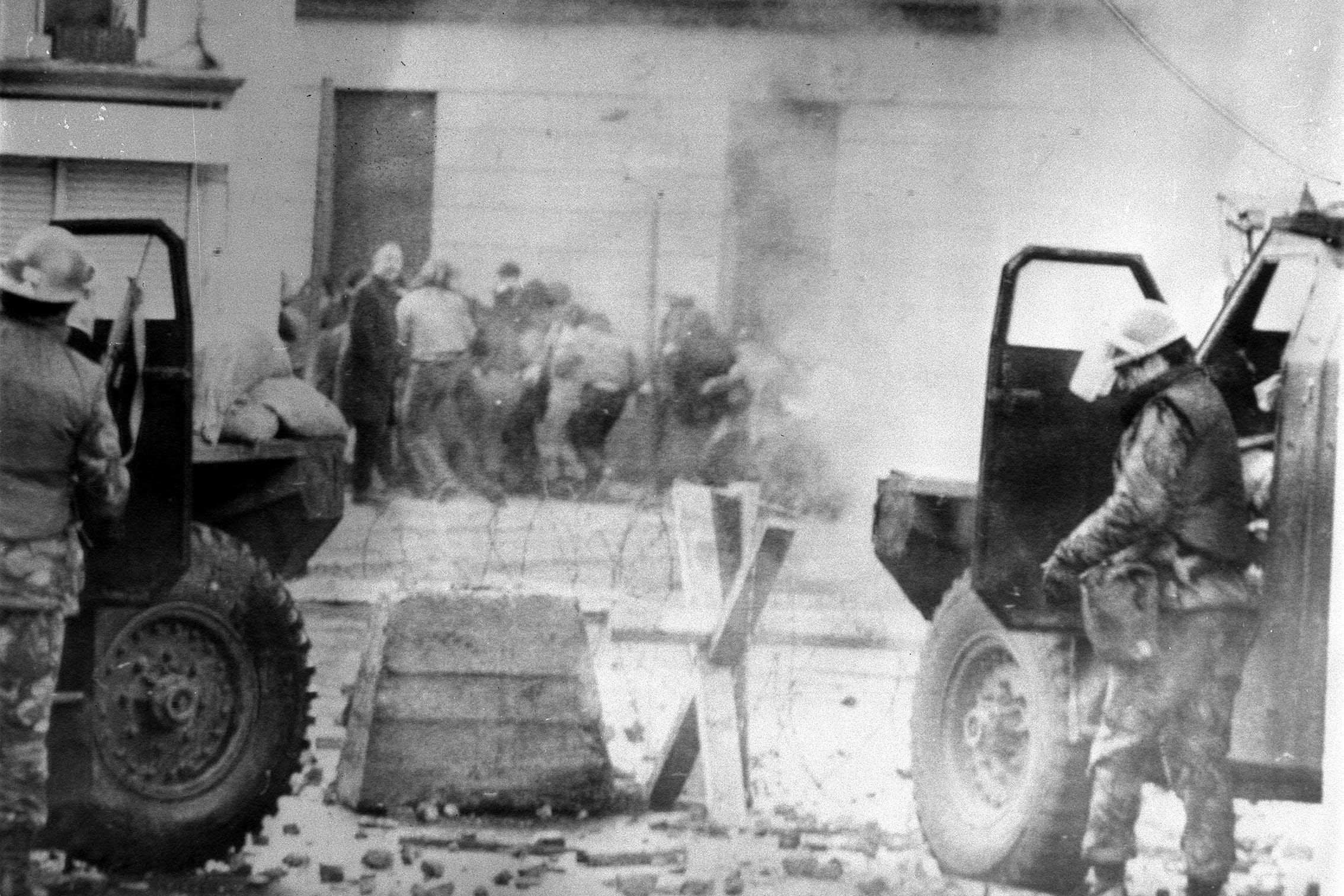 File photo dated 30/1/1972 of soldiers take cover behind their sandbagged armoured cars while dispersing rioters with CS gas in Londonderry, where a civil rights march culminated in a clash between troops and demonstrators, which resulted in 13 people being shot dead (PA).