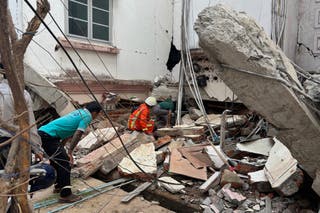 Volunteers look for survivors near a damaged building in Naypyitaw