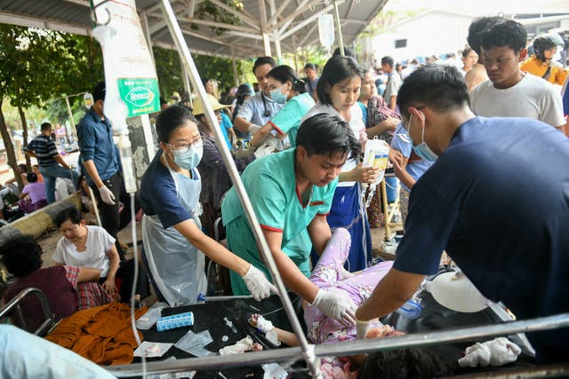 <p>Medical workers treat a earthquake survivor on a bed in the compound of a hospital in Naypyidaw, the capital of Myanmar</p>