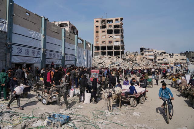 <p>Palestinians receive bags of flour and other humanitarian aid distributed by UNRWA, the U.N. agency helping Palestinian refugees in Jabaliya, Gaza Strip on Tuesday, March 25, 2025</p>